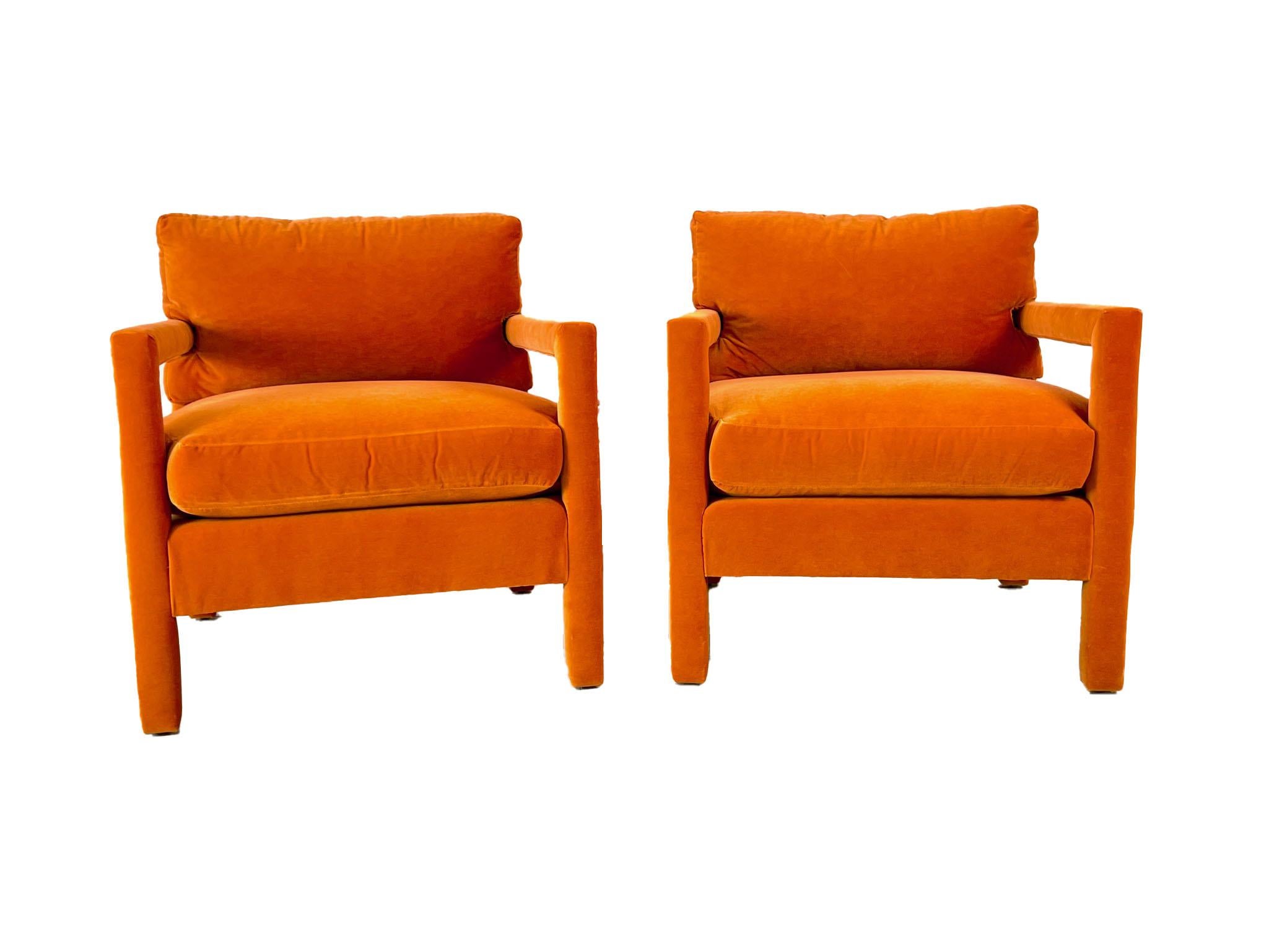 A pair of newly upholstered orange velvet Parsons chairs, inspired by the iconic style of Milo Baughman. These chairs feature clean lines and a minimalist design, perfectly capturing the mid-century modern aesthetic. The vibrant orange velvet