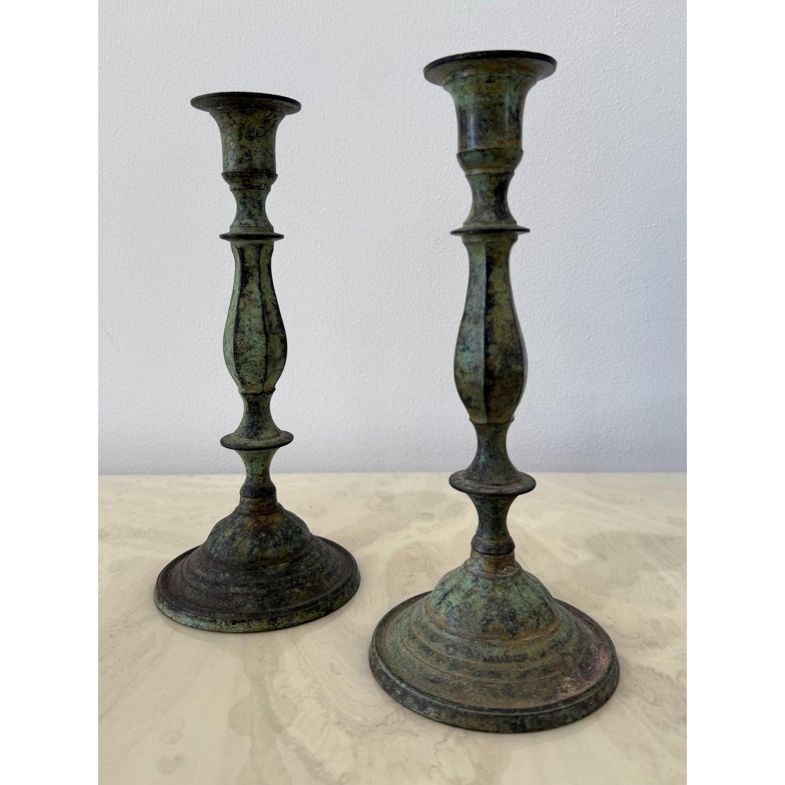Questa sorprendente coppia di candelieri vintage presenta silhouette alte e slanciate con colonne graziosamente tornite e basi larghe per garantire la stabilità. Una patina di verderame invecchiato naturalmente aggiunge profondità e ricchezza alla