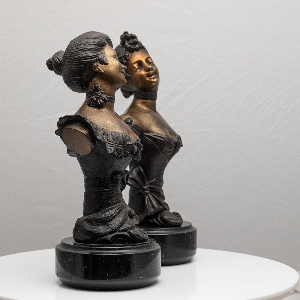 A pair of young women that give off this vibe of being best friends and having a great time. Their smile is infectious. The patinated bronze busts are in excellent condition. The black marble bases match their short-sleeved black Victorian dresses,