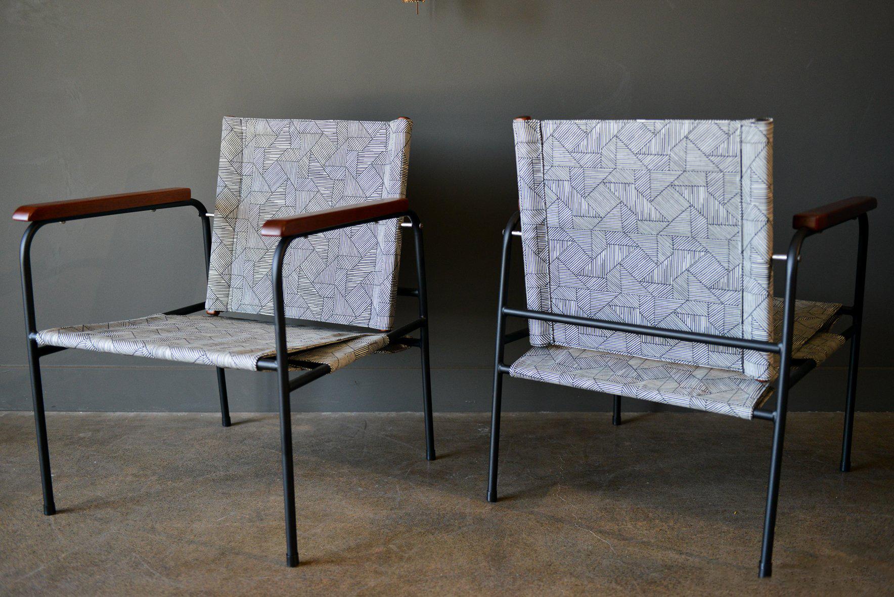 Pair of vintage Patio chairs, circa 1970. Professionally restored with new black powder coat on the metal frame, refinished wood armrests and new geometric pattern black and white outdoor fabric. Backrest swivels for maximum comfort. 

Measures: