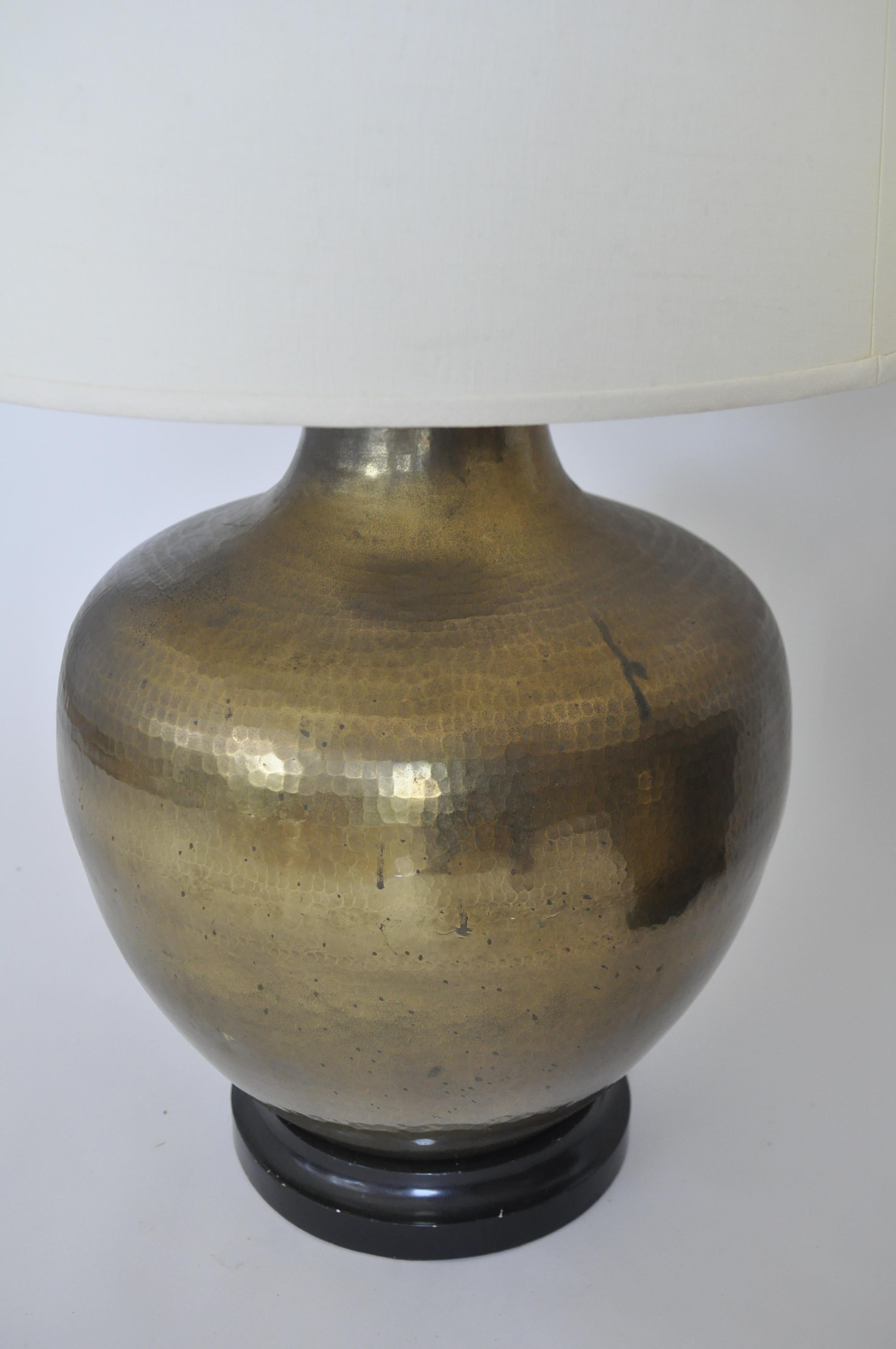 Cette étonnante paire de lampes de table vintage de Paul Hanson, datant des années 1960-1970, présente des corps généreux en laiton martelé à la main avec une patine chaude et vieillie, posés sur des bases en bois ébonisé.  Paul Hanson a été actif