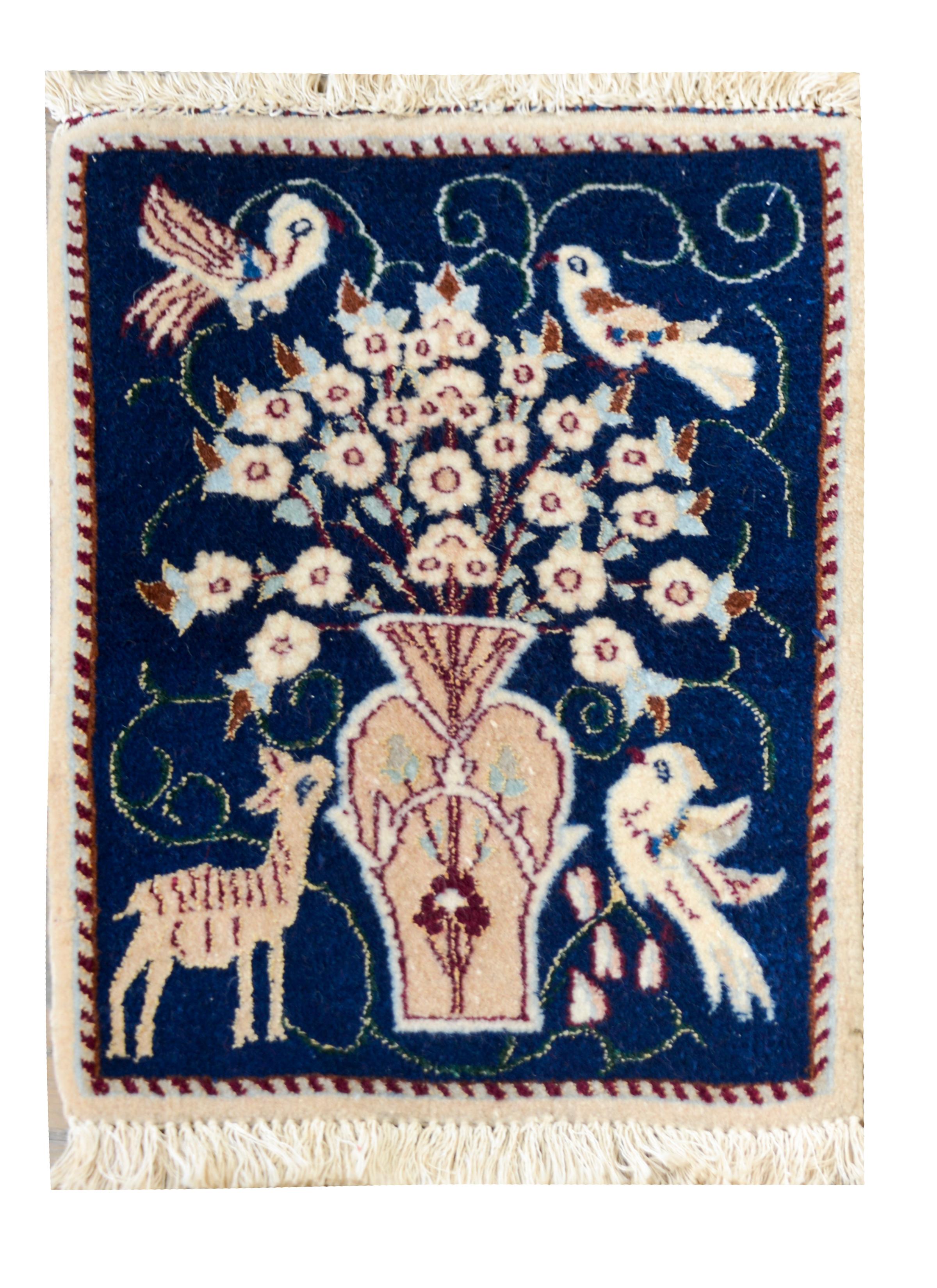 Une merveilleuse paire de tapis persans de Nain du milieu du 20e siècle, chacun représentant un grand vase central avec des fleurs et des oiseaux perchés dans les branches, et un cerf et un oiseau flanqués sur le vase en dessous. Il est très rare de