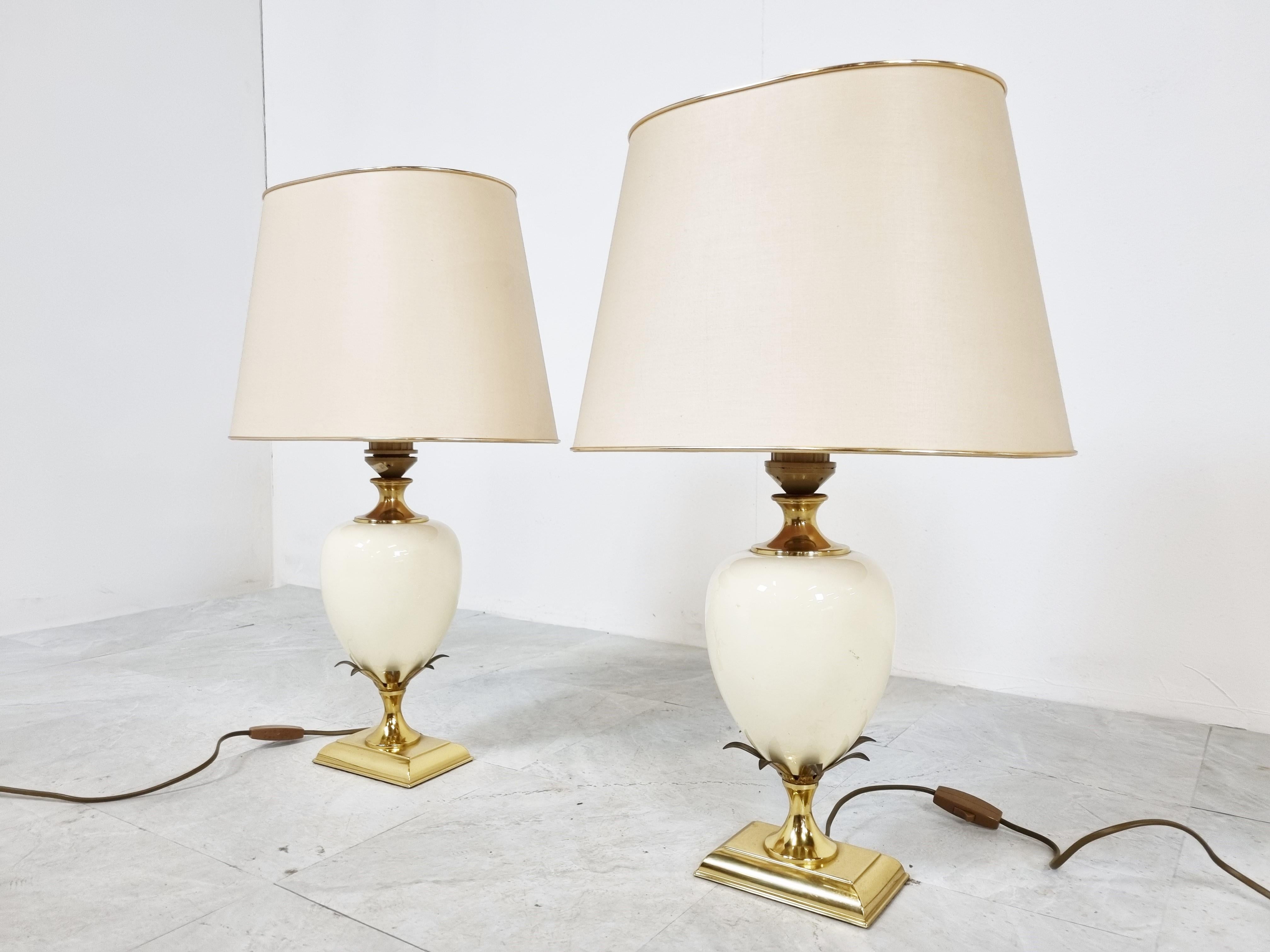 Beautiful pineapple/egg shaped table lamps by Maison Le Dauphin.

These luxurious lamps have an egg shaped center piece finished with brass leafs.

Very good condition with original lamp shades

They work with one standard E27 light bulb and