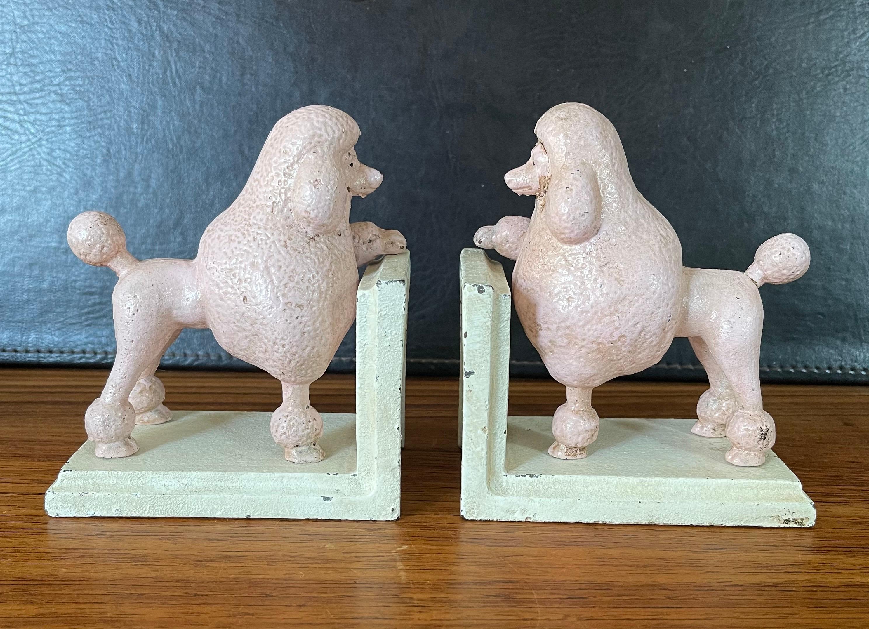 A super fun pair of vintage pink poodle cast iron bookends circa 1930s. The bookends are in fair condition with some wear and chips to the paint; they measure 10.5