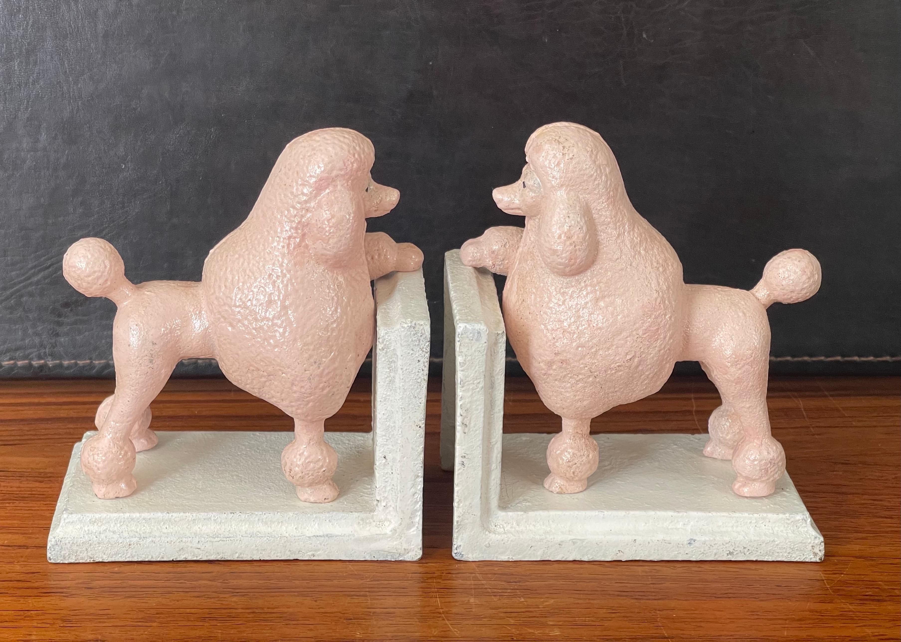 A super fun pair of vintage pink poodle cast iron bookends circa 1950s. The bookends are in fair condition with some wear and chips to the paint; they measure 10.5