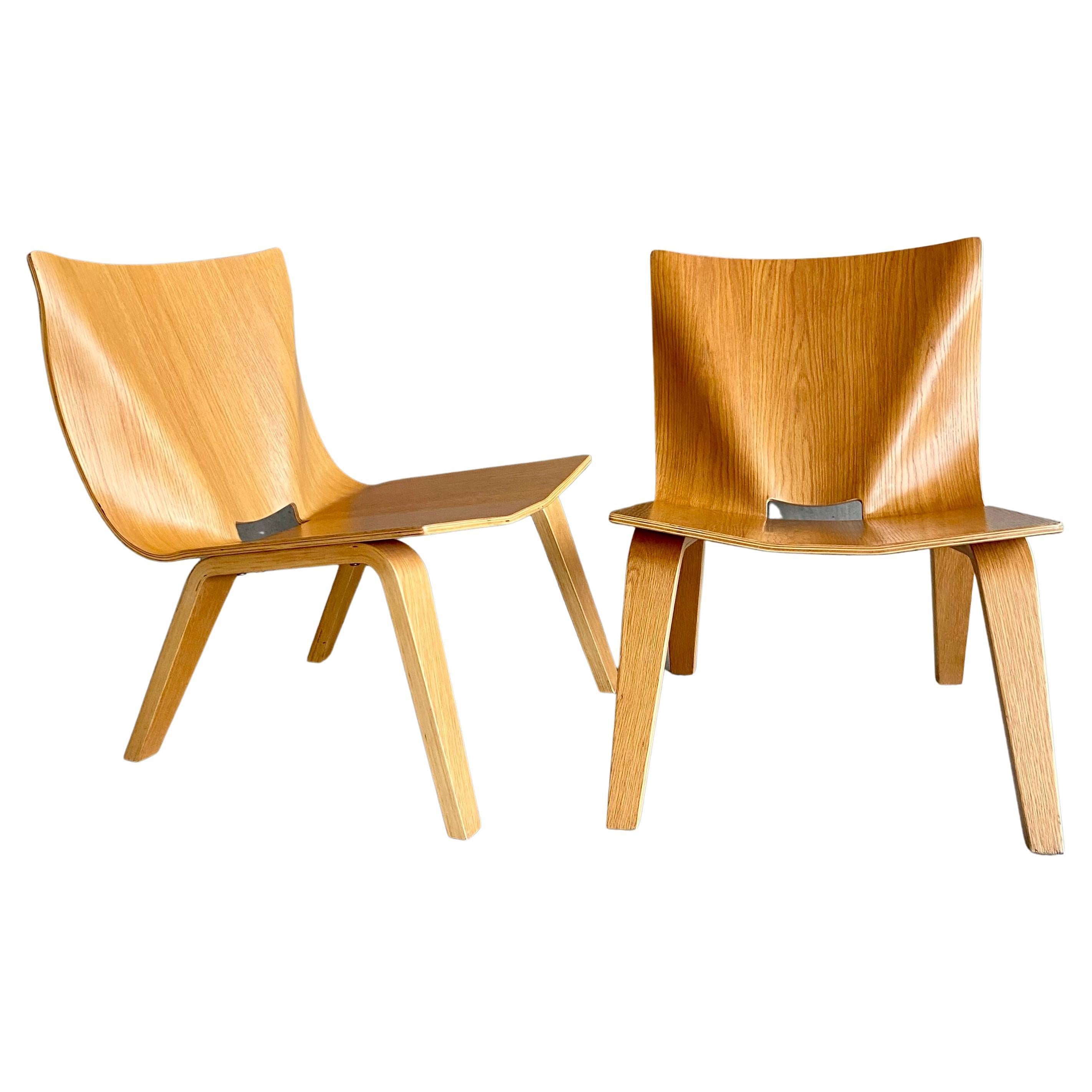 Wir stellen Ihnen ein Paar exquisite, niedrige Sessel aus Eichenfeinsperrholz vor, die eine perfekte Mischung aus Stil, Komfort und Handwerkskunst darstellen. Diese Stühle sind gut verarbeitet, mit schönen, gut durchdachten Faltlinien sowohl auf der