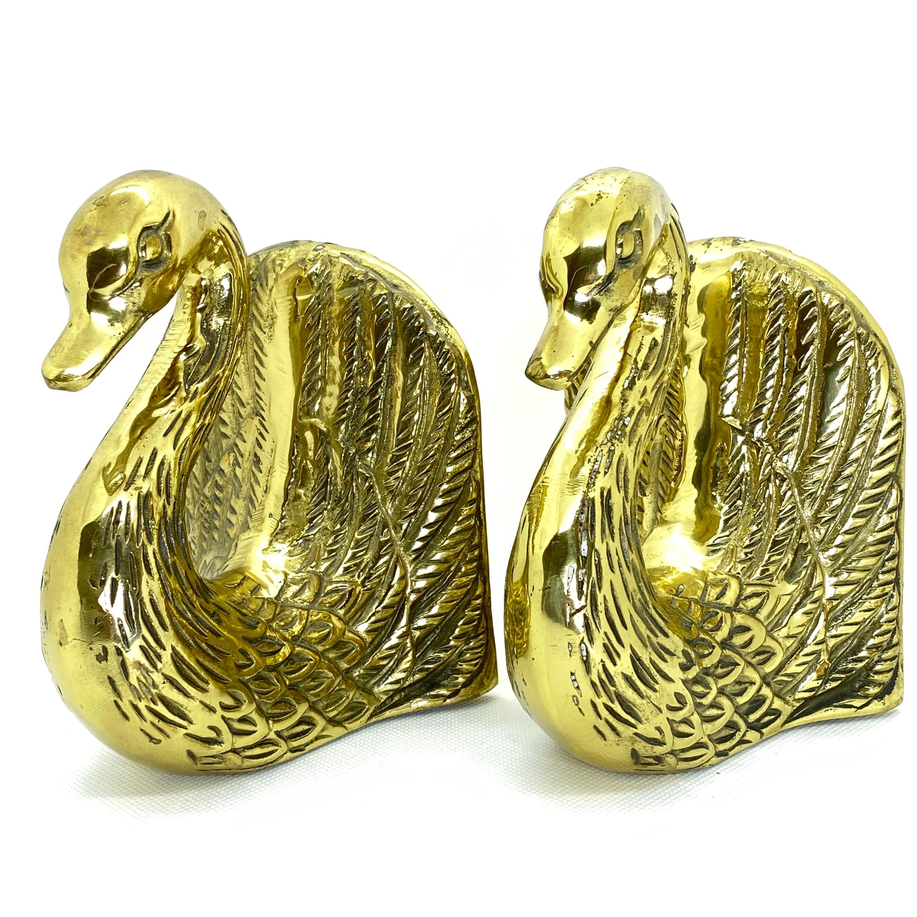 Vintage pair of polished cast brass Swan bookends, circa 1950. Very sturdy and heavy. Great for holding up books on a bookshelf or as paper weights on a desk or decorative animal sculptures around the house. They have a beautiful patina.