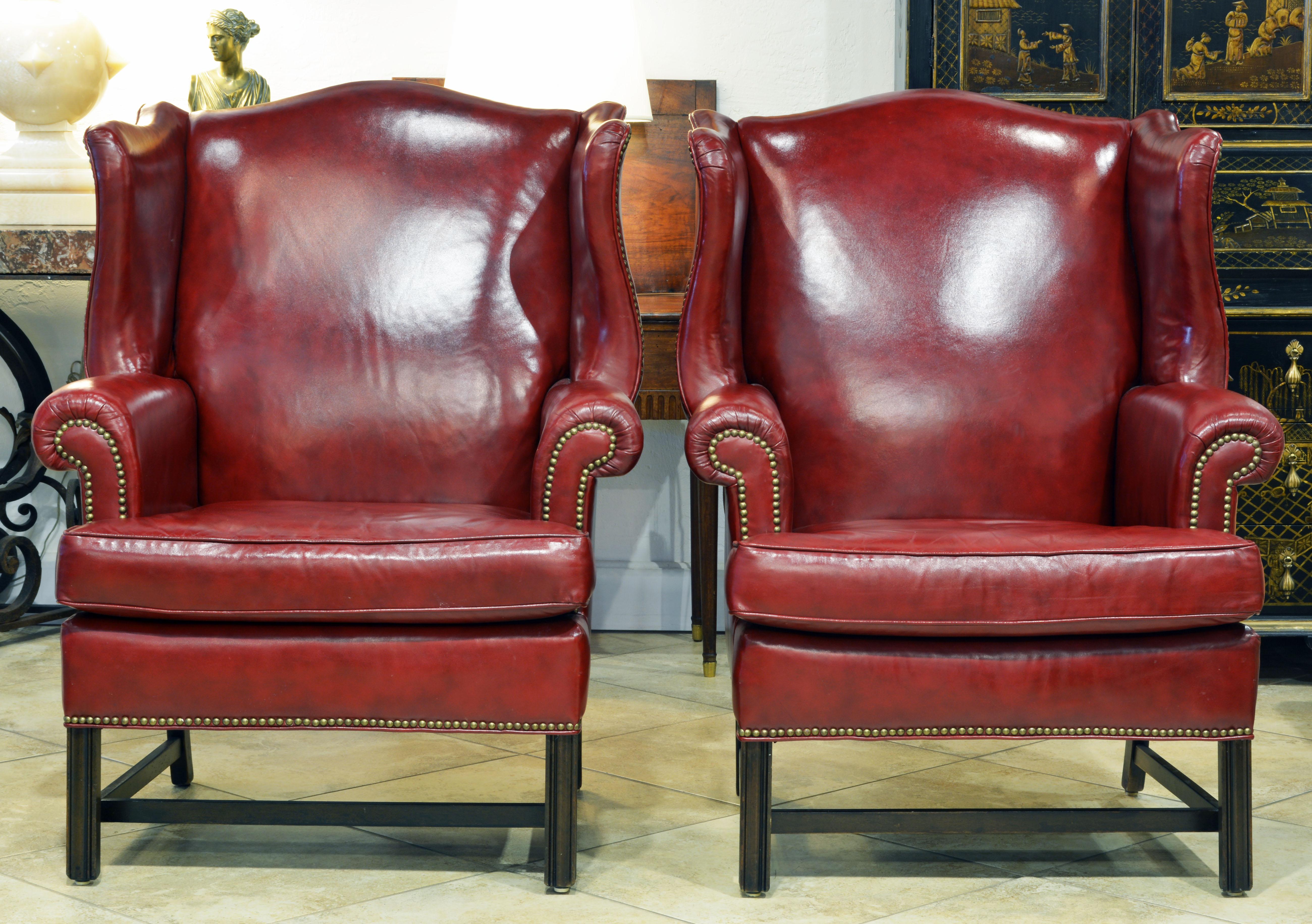 Of a great sculptural form, generous proportions and covered with burgundy red leather trimmed with nailheads these chairs evoke the feeling of the English country house.