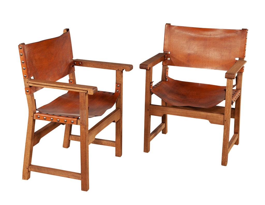 Pair of Vintage Ralph Lauren leather oak campaign arm chairs. Early original Ralph Lauren furniture design. Natural oak frames with distressed saddle leather. Completed with brass and metal nail heads. Traditional campaign styling, USA, Circa