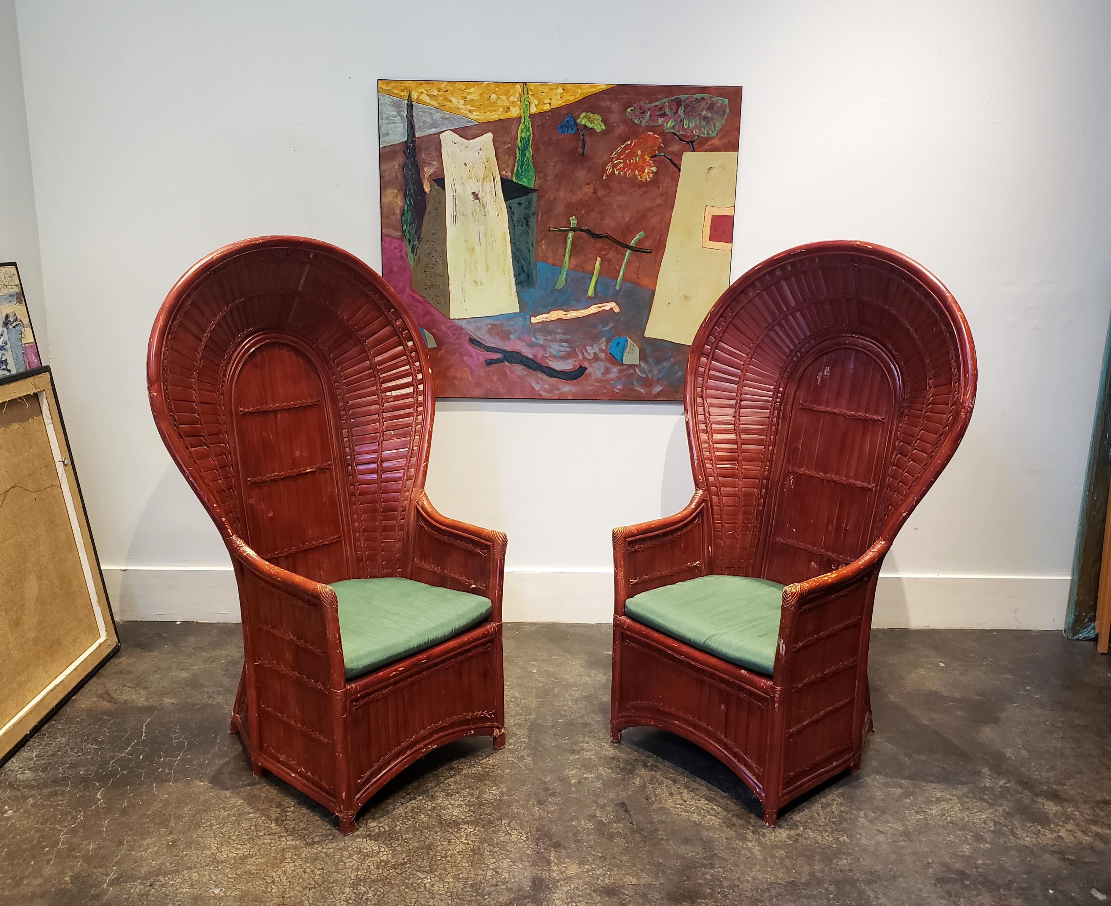 Pair of 1960s-1970s amazingly crafted rattan and bamboo peacock chairs. Vintage oxblood red-paint job has beautiful worn-in patina. Chairs come with two emerald green cushions.
 