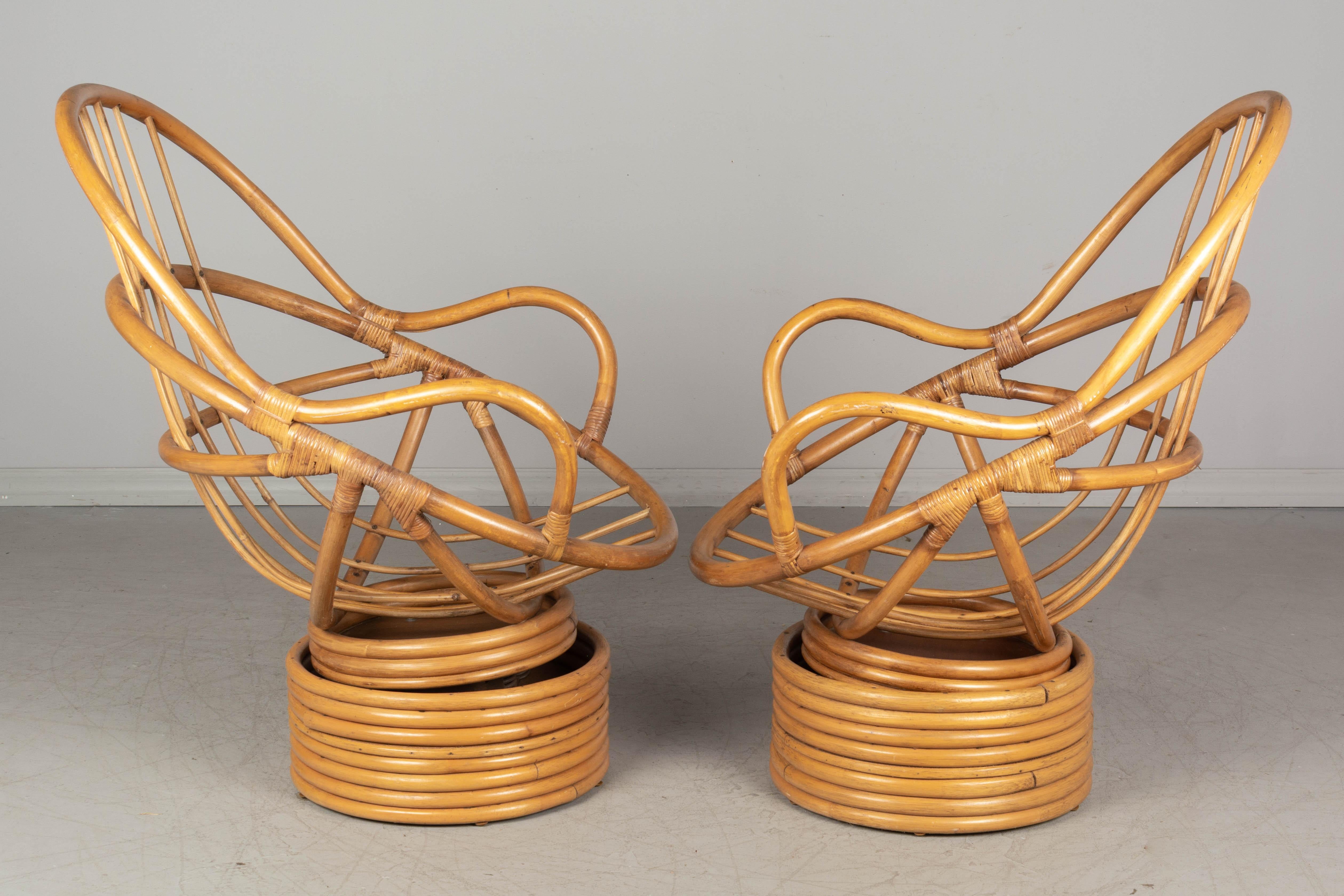 A pair of Mid-Century Modern rattan lounge chairs with bucket shape that conforms to the human body. No cushions. Excellent vintage condition. Casual boho California style, perfect for living room, sunroom or lanai. Contact us for a competitive