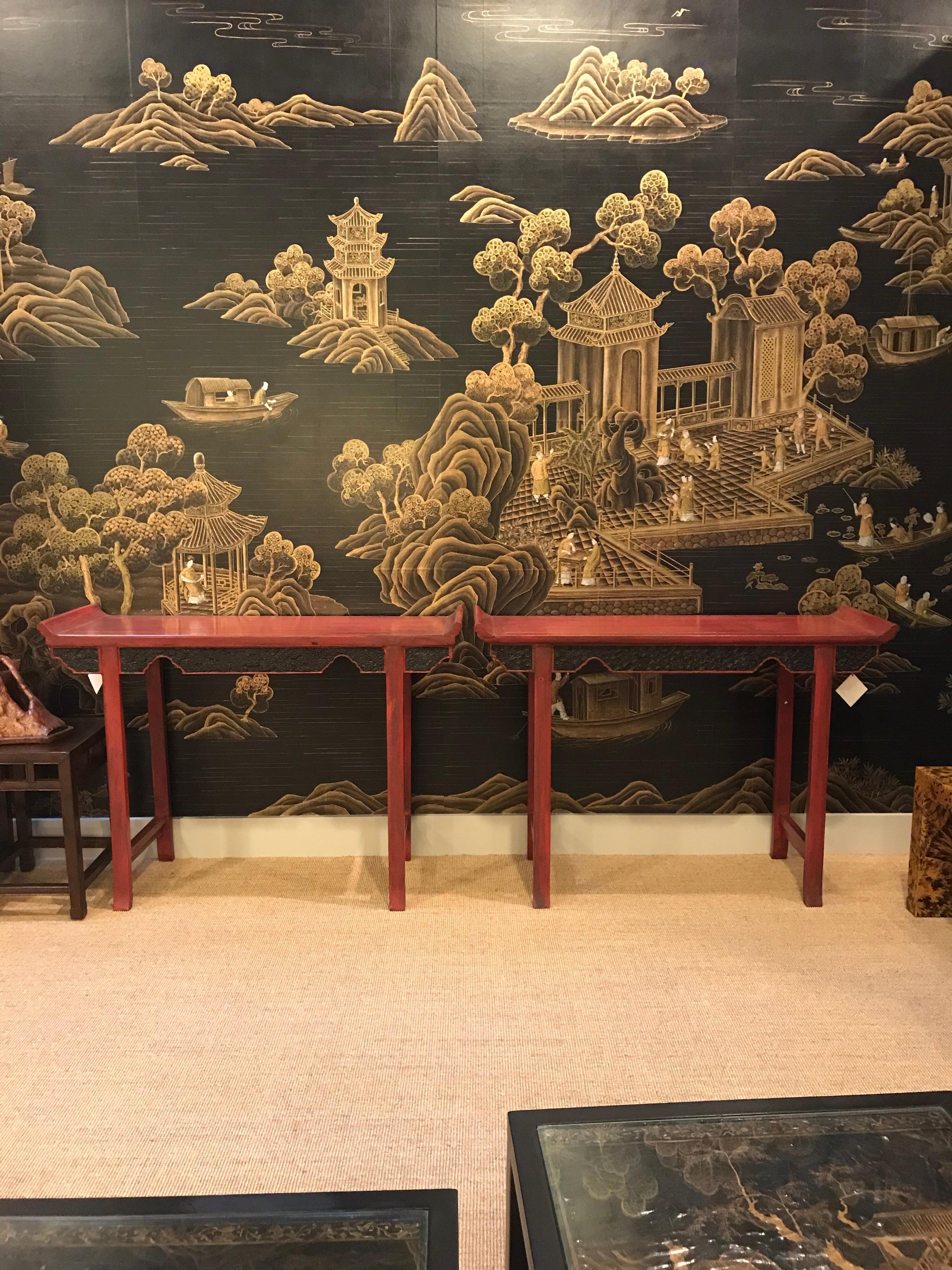 A pair of Chinese red lacquer console tables, available as the pair, or individually.

Finished in deep red lacquer, the aprons have intricate carved design, and the tops have upturned ends.