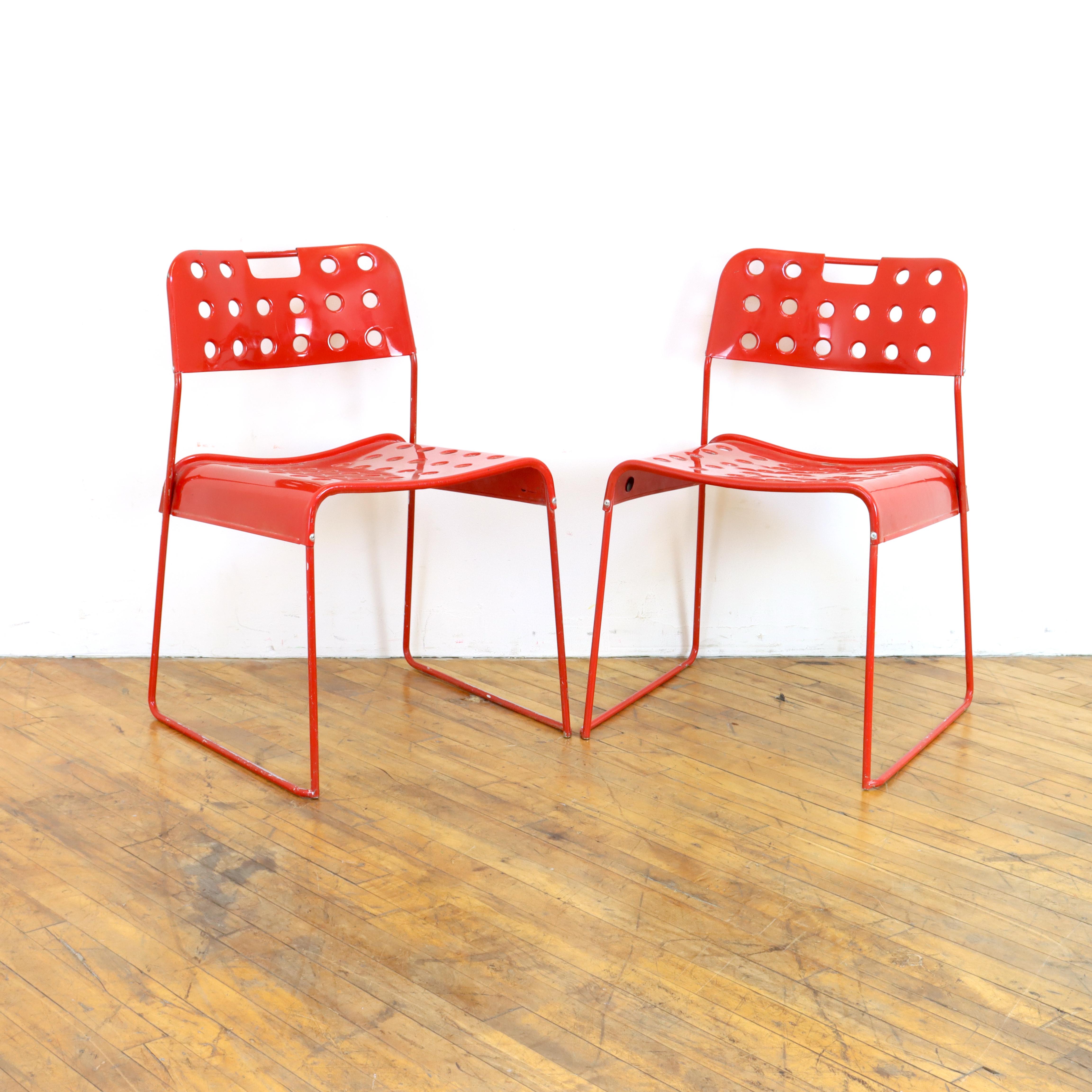 Pair of vintage 1970s Omkstak chairs in red by Rodney Kingsman for Bieffeplast. Wire frame and perforated 
metal seat and back, powder coated.  As the name suggest, they also stack.  Can be used indoors or out.  

18.5” W x 18” D x 30” H
Seat
