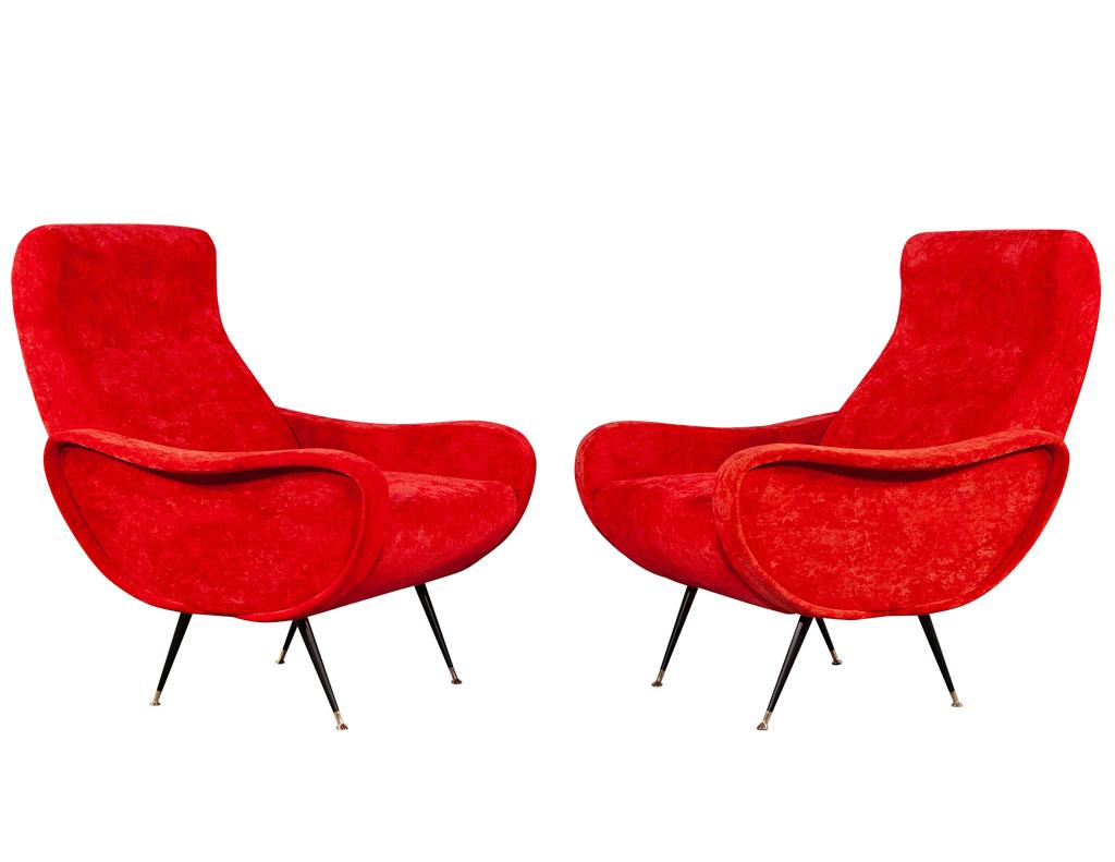 Pair of vintage red velvet Italian lounge chairs. Italy, circa 1980s with inspired Mid-Century Modern design. Upholstered in a red velvet covering. All original in good condition. Resting upon 4 sleek stain black metal legs with metal foot caps.
