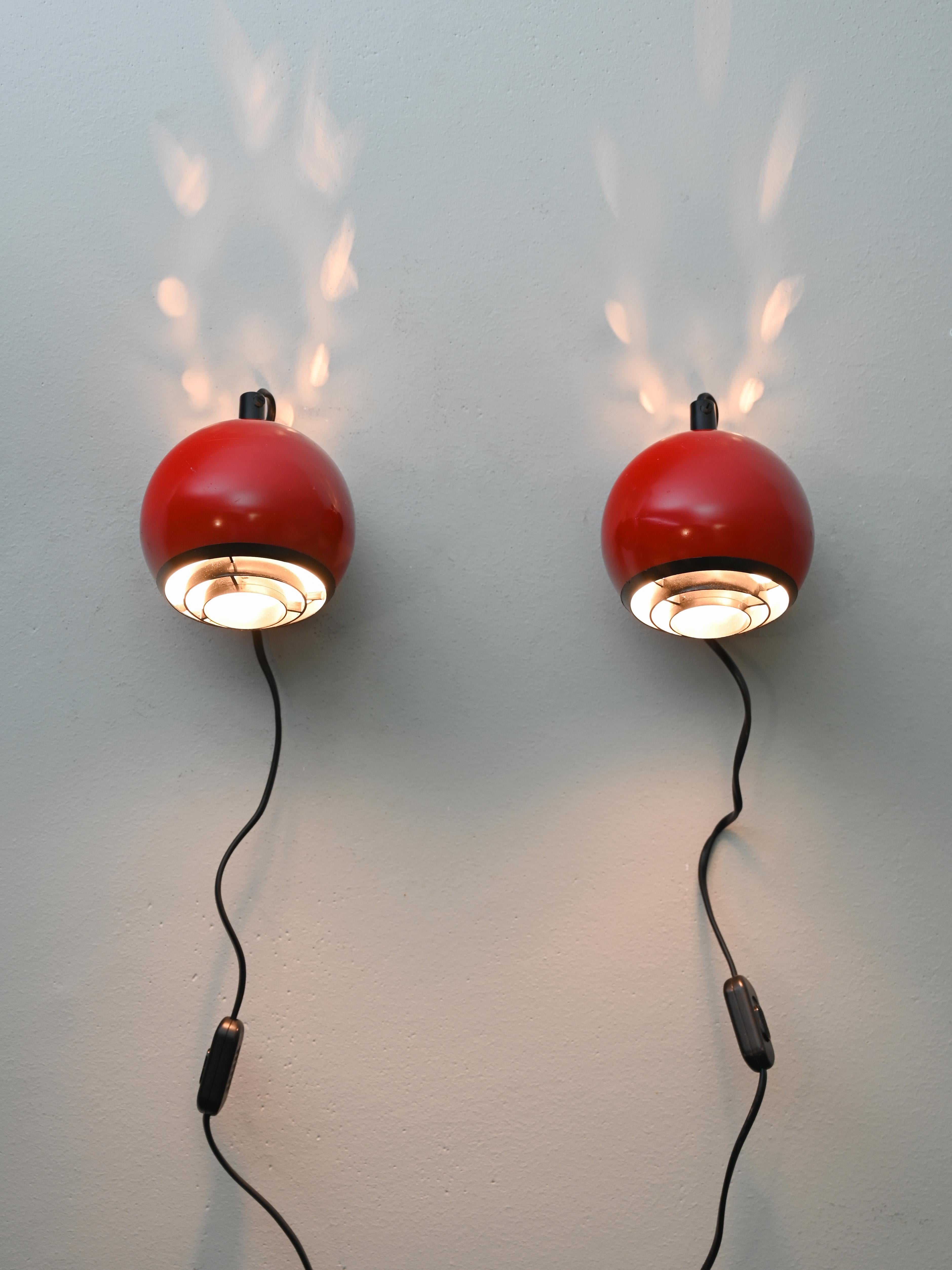 Pair of original 1960s metal and plastic wall lamps.
These original vintage lamps trace the mid-century modern style. The round lampshade
features a black plastic grid that filters and diffuses light evenly.
Ideal for use in the bedroom, they