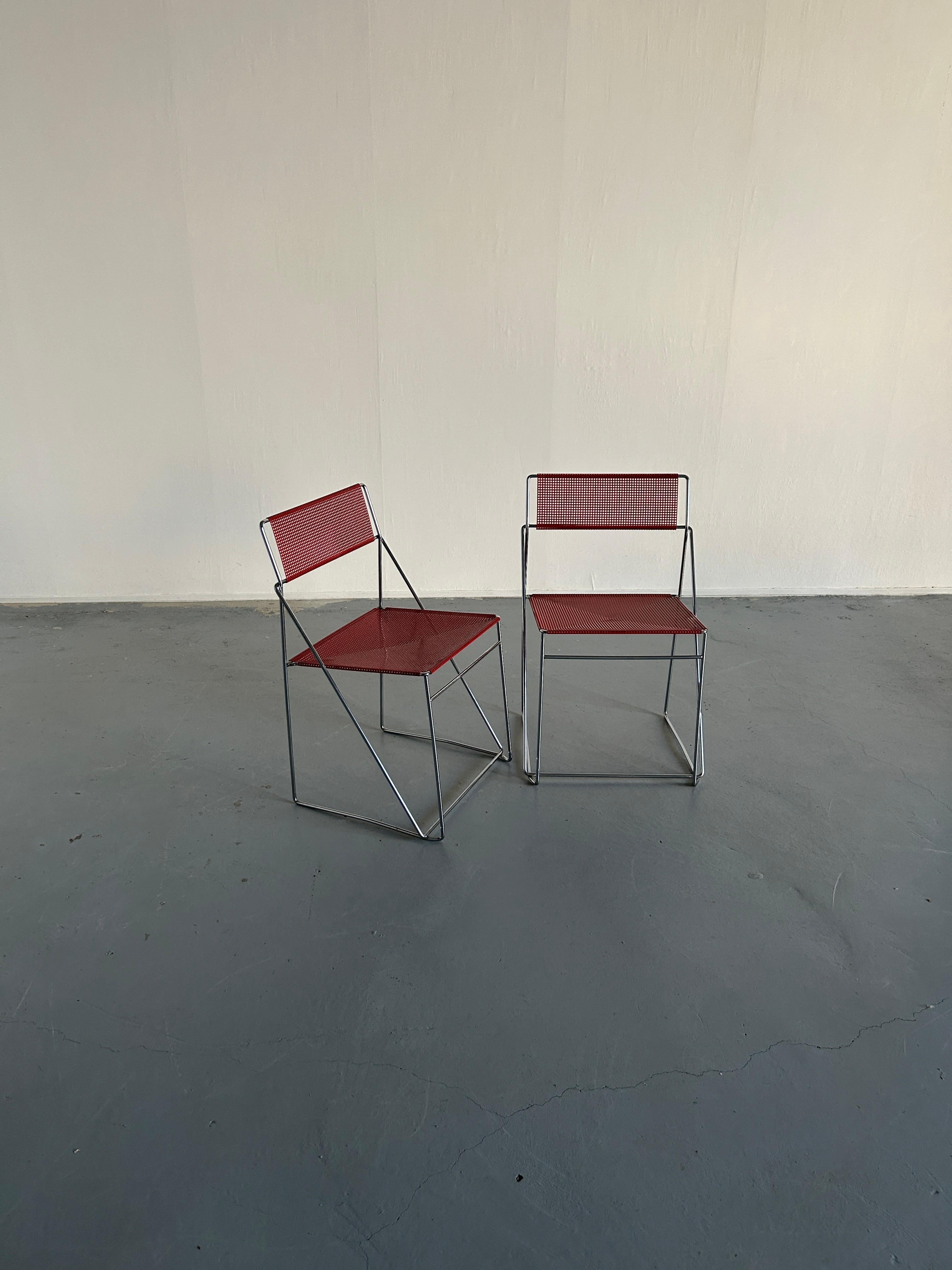 Pair of minimalist postmoderns X-Line chairs designed by Niels Jorgen Haugesen for for Bent Krogh, Denmark.
Made of chrome plated steel rods and red enamelled perforated steel backs and seats.
Stackable. 

In very good vintage condition with