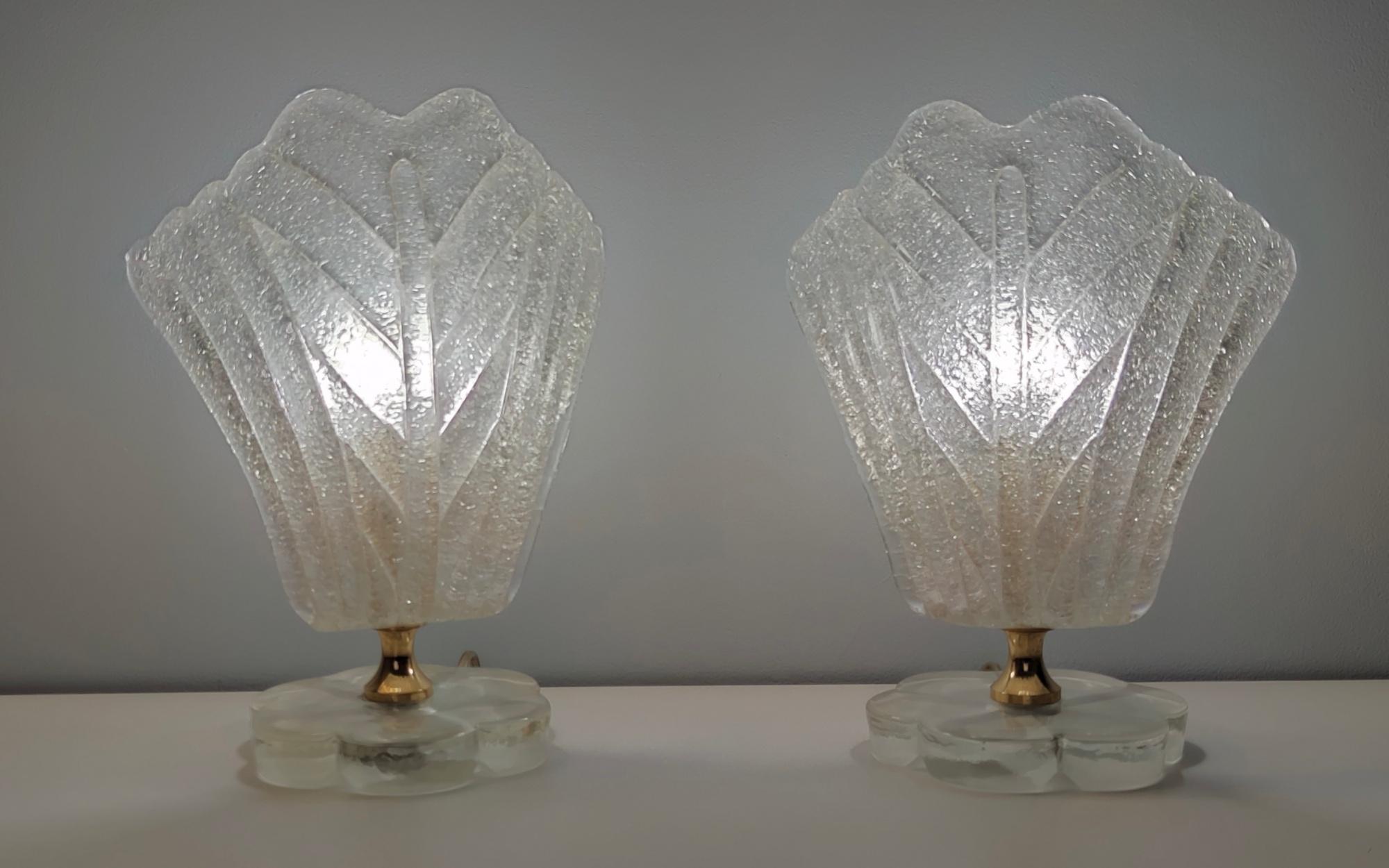 Italy, 1950s.
These table lamps are made in Murano glass and brass.
They feature a really 2.5-centimeter thick flower-shaped glass base.
These lamps are vintage, therefore they might show slight traces of use, but they can be considered as in
