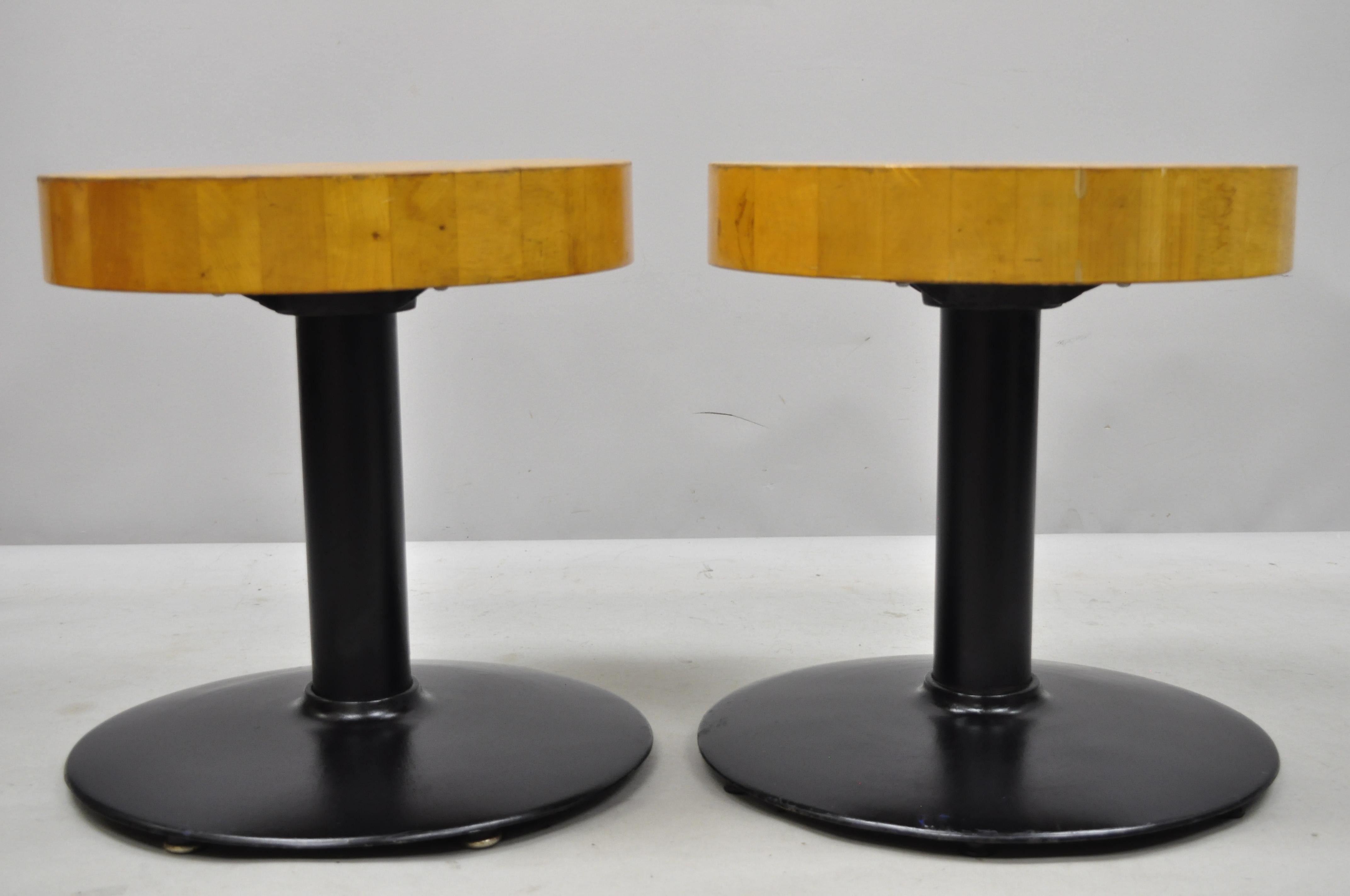 Pair of vintage round butcher block wood industrial cast iron pedestal stools. Listing includes thick butcher block wooden seat, cast iron base with black painted finish, clean modernist lines, quality American craftsmanship. Each stool weighs