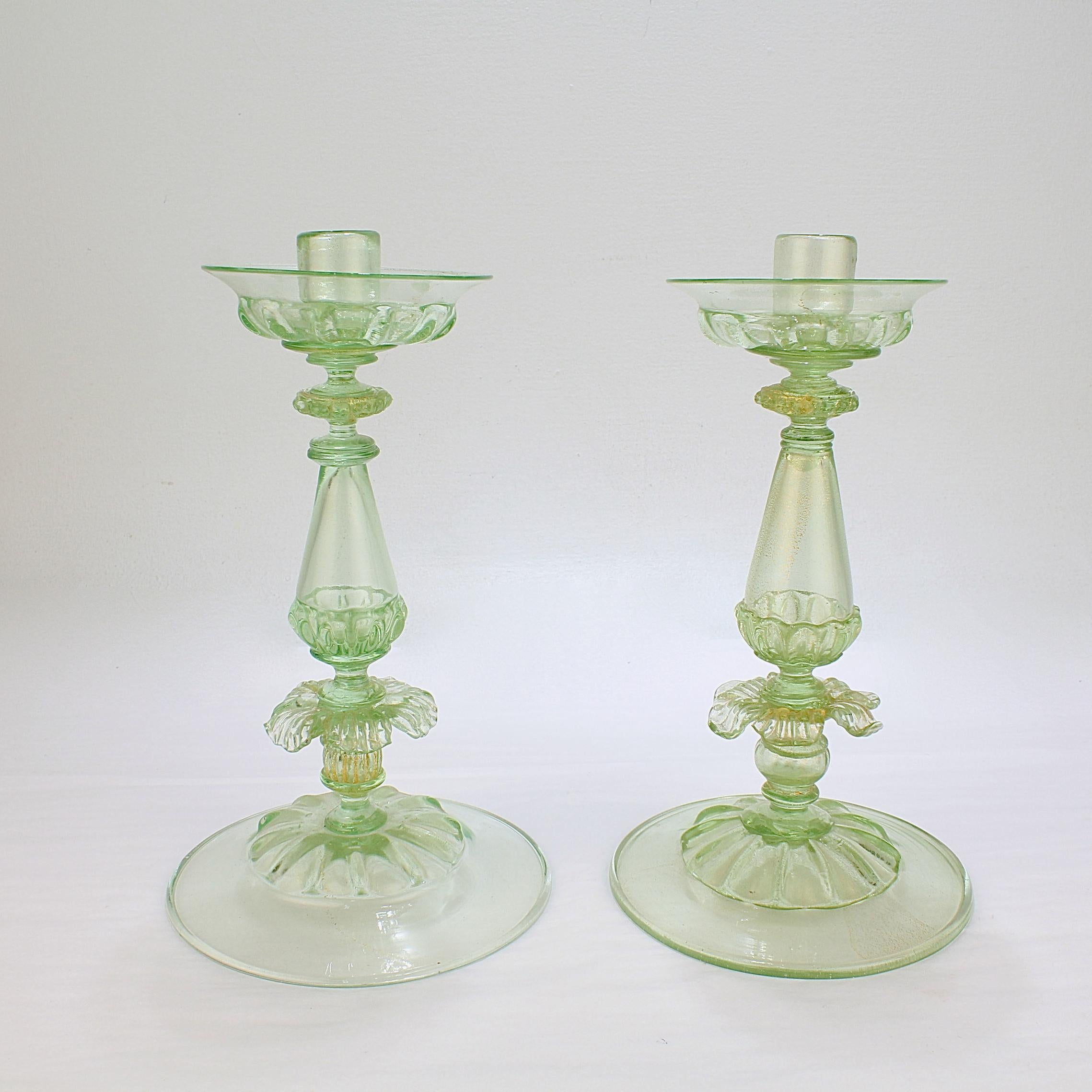 A fine pair of Venetian glass candlesticks. 

Attributed to Salviati.

 In lime green (almost uranium colored) glass with gold foil inclusions throughout.
 
With stylized floral decoration to the pedastal. 

Simply wonderful large-scale
