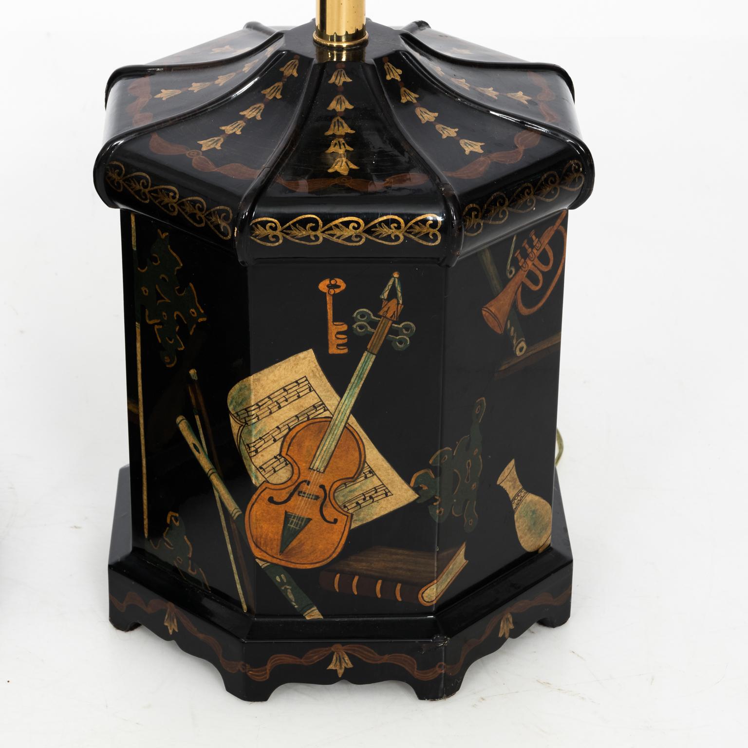 Pair of Vintage Papier-Mache Black Lacquer Sarreid Lamps with painted musical instruments and sheet music, circa mid-20th century. The lamps are in an octagonal shape with the original label on the bottom. Please note of wear with age including