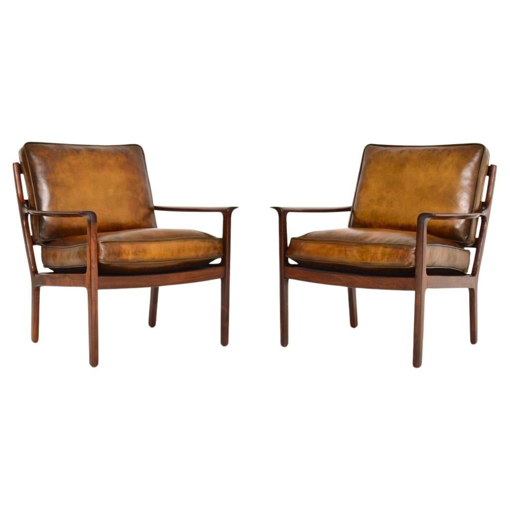 Coppia di poltrone scandinave d
epoca in palissandro e pelle di Frederik Kayser