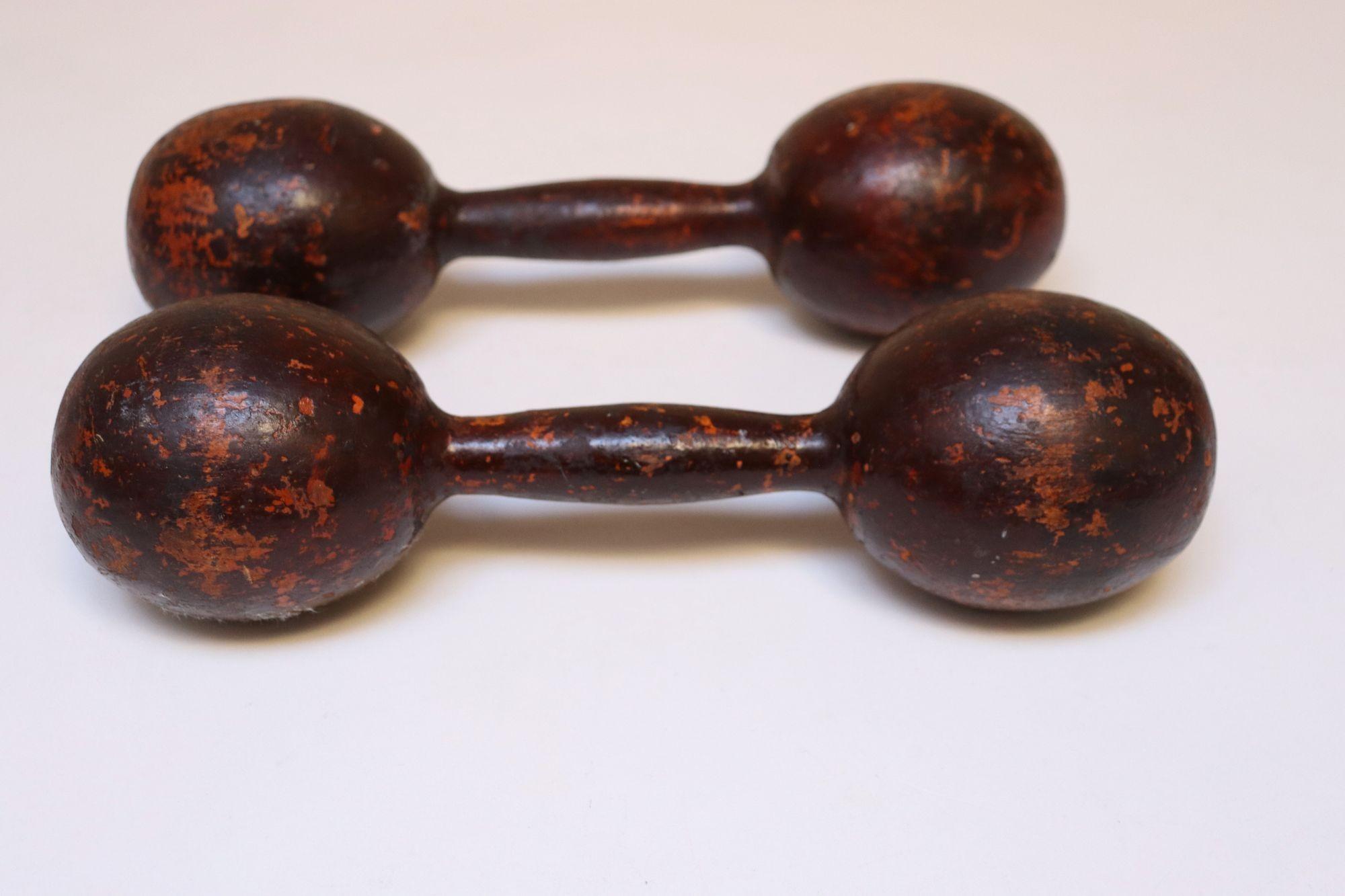 Paire d'haltères américains sculptés à la main vers les années 1930, chacun provenant d'une seule pièce de bois continue ayant conservé sa teinte acajou profonde d'origine.
Parfaitement vieillie avec une riche patine et des pertes de finition sur