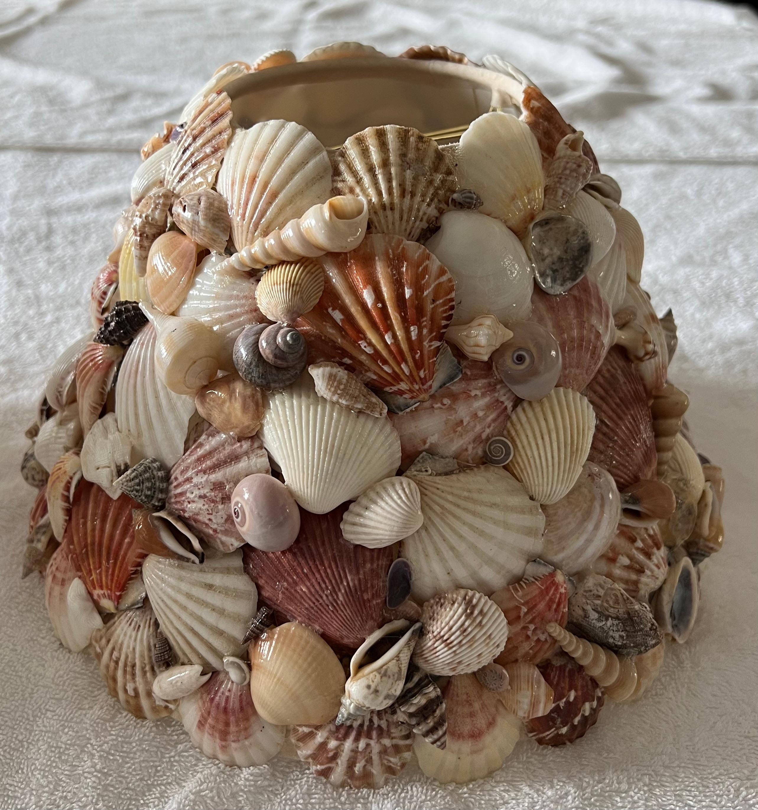 These vintage seashell encrusted lampshades evoke the glamour of Palm Beach and Lyford Cay. Constructed with Atlantic and Caribbean seashells including fan scallops, Scotch bonnets, cockles, cones, conchs, clams, tulips and auger shells, the palette