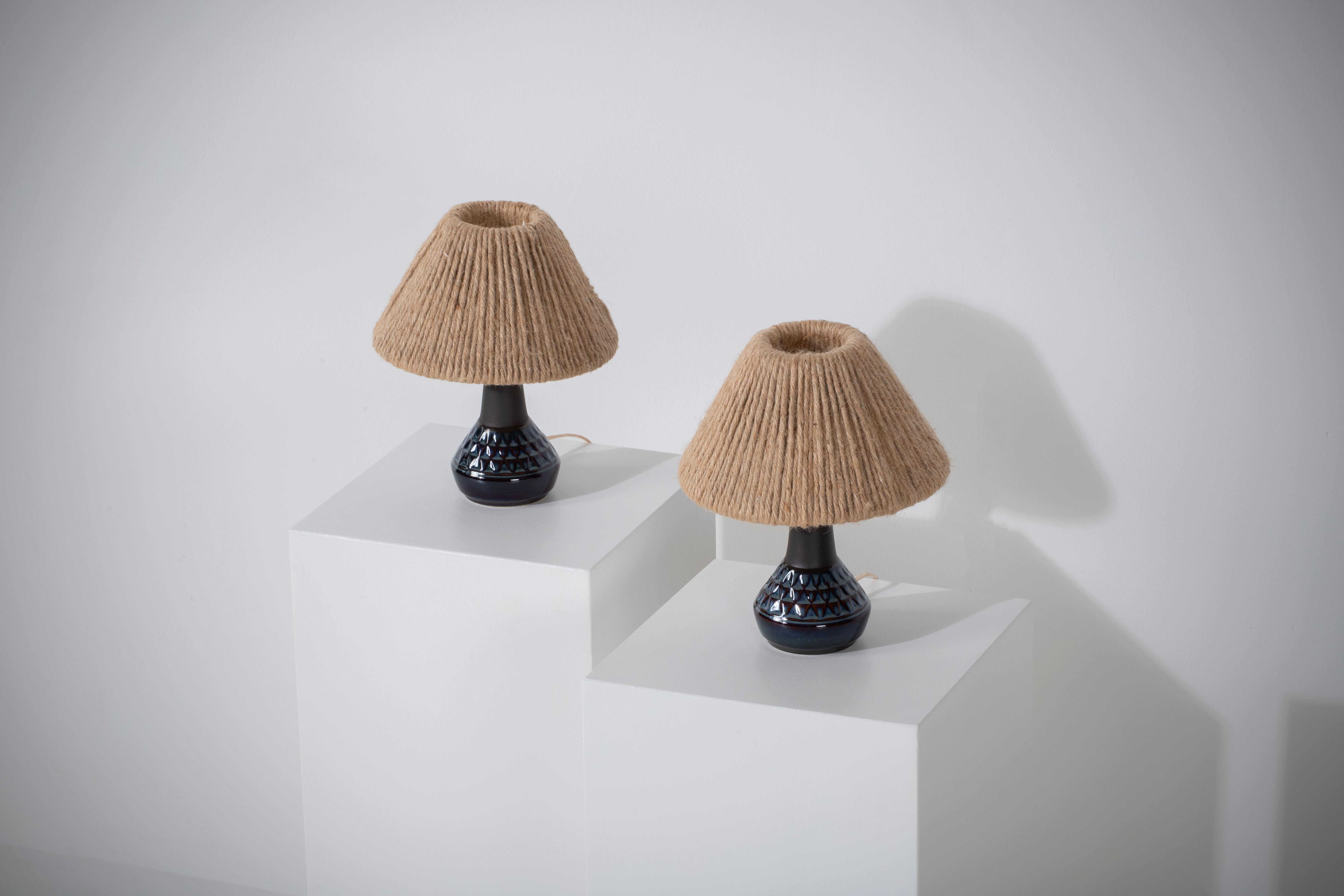 This is a pair of elegant table lamps designed by Einar Johansen and crafted by Søholm in Bornholm, Denmark, in the 1960s. 
The lamps are made of stoneware and feature a signature by the designer and the maker, including 