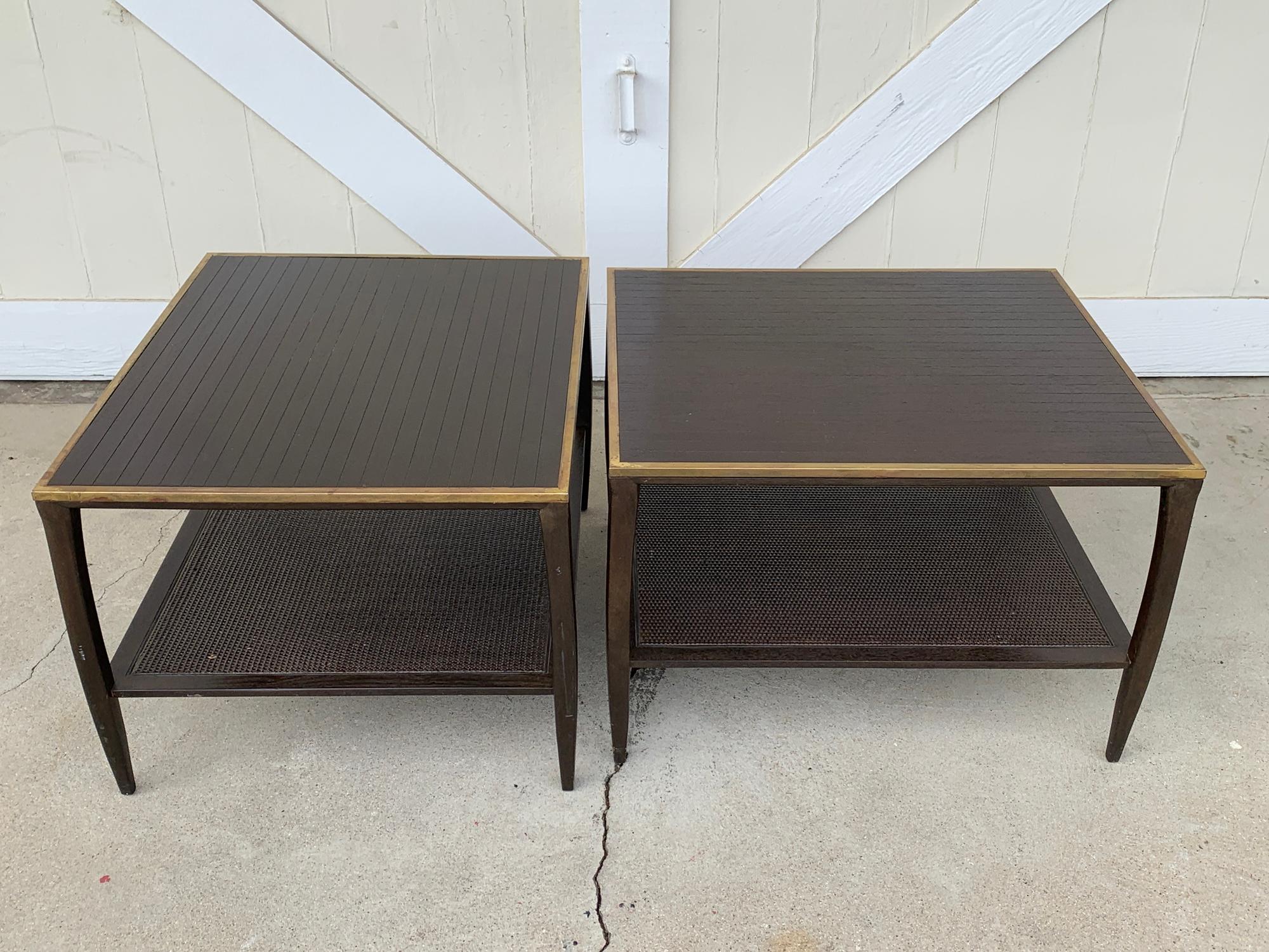 Beautiful pair of side or end tables in the manner of Paul McCobb.
The tables have beautiful dark wood frames with a brass trim and weaved rattan bottom shelf.
The tables are in good vintage condition with minor nicks and scuffs but can be used in