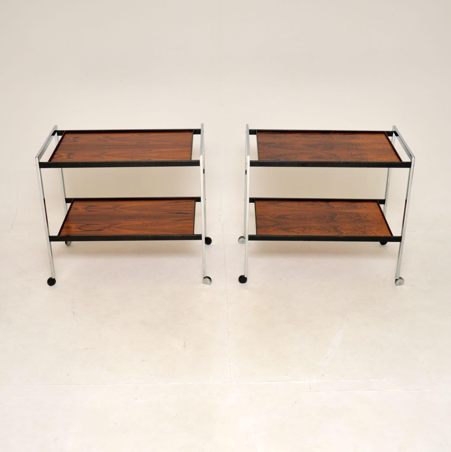 A stunning pair of vintage side tables / drinks trolleys. They were made in England, they date from the 1960’s.

The quality is superb, they are beautifully constructed from chromed steel, with ebonized steel supporting the wooden top and lower