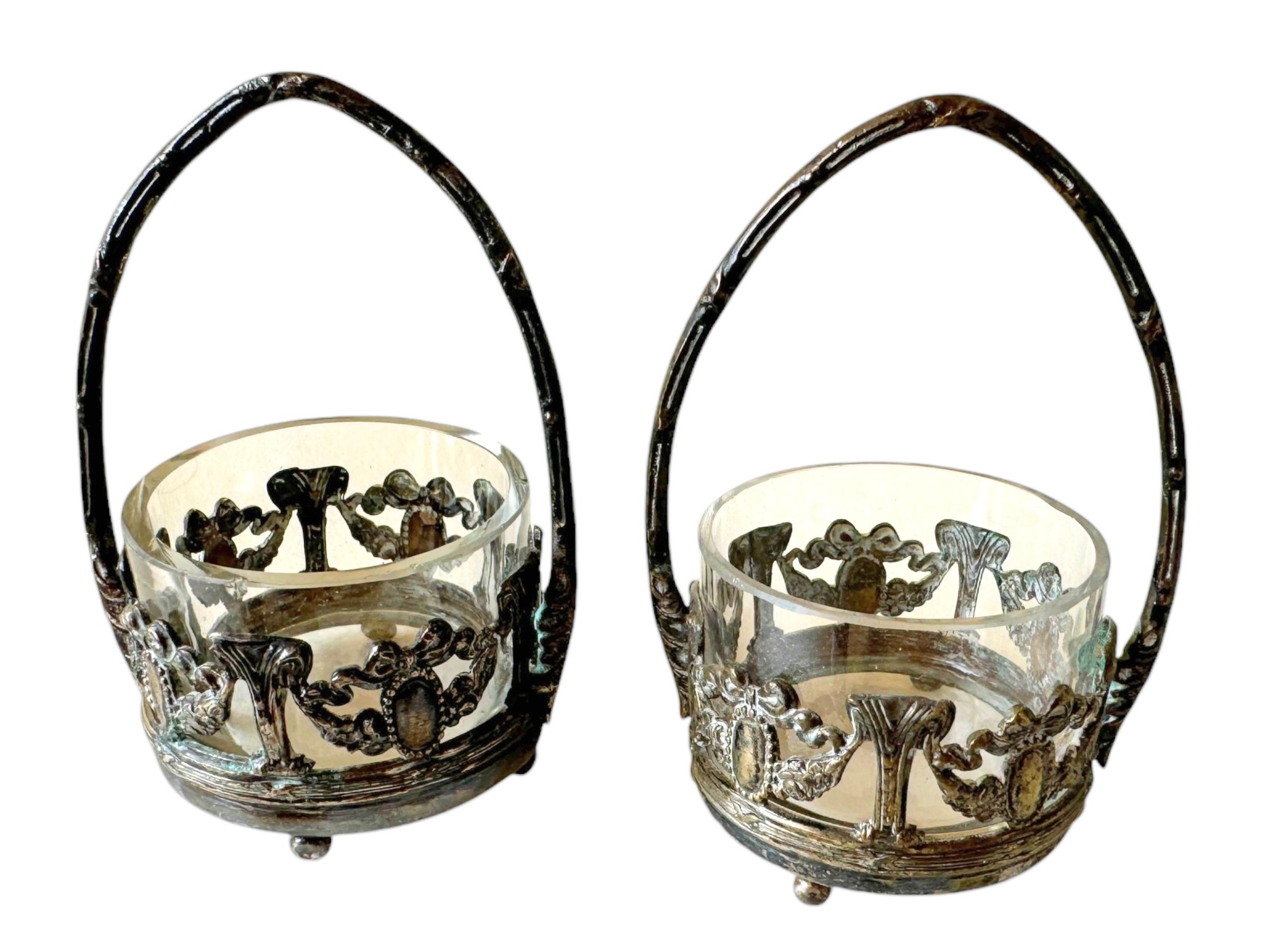Un par de antiguas vasijas decorativas abiertas para sales. De metal plateado e inserciones de cristal. Un bonito artículo vintage original para exponer o simplemente para utilizar en tu mesa. Cada uno en su estado original. Cada pieza tiene una