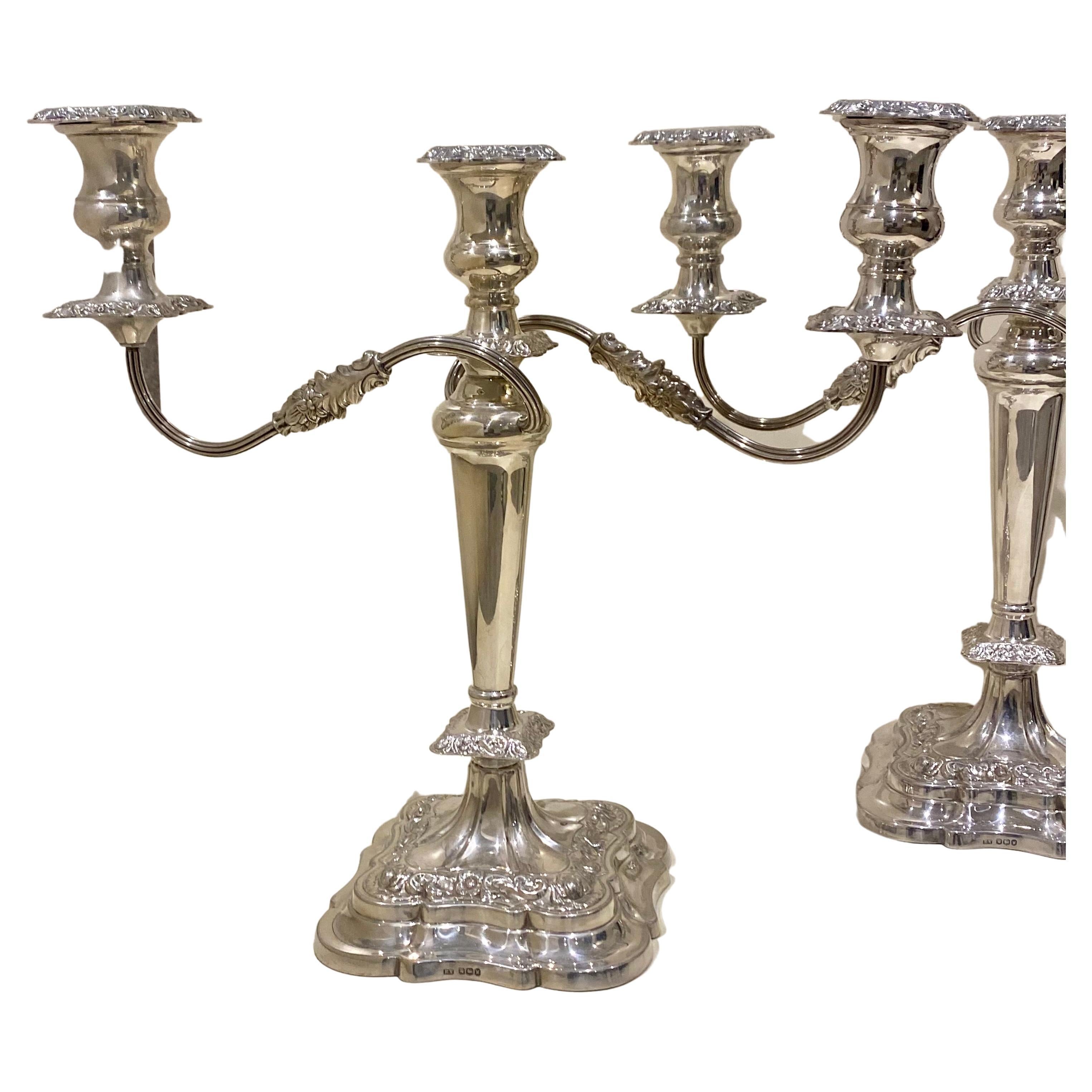 A high quality pair of sterling silver three light, two branch candelabra by highly regarded English silver smiths Emile Viners, Sheffield, circa 1964, 
The vase shape capitals with gadrooned borders and drip pans, two floral and reeded scroll