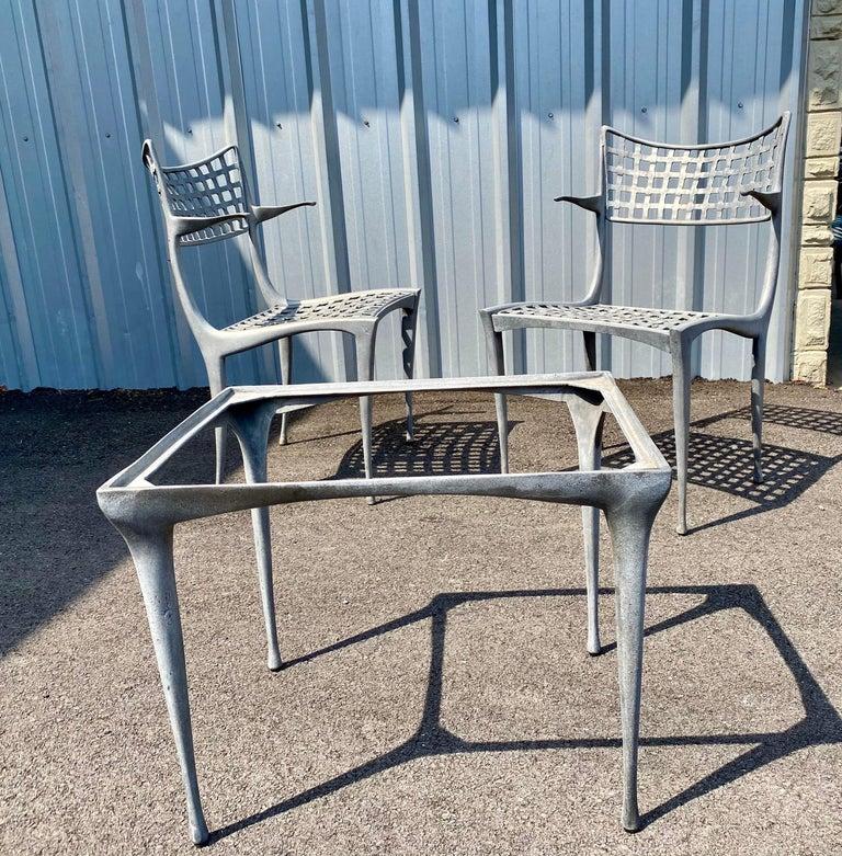 Pair of Sol Y Luna patio chairs with arms and a side table by Dan Johnson for Brown Jordan. Patio chairs and patio table is made of cast aluminum and powdered coated. **The patio side table is having new glass made. This set is perfect for a small