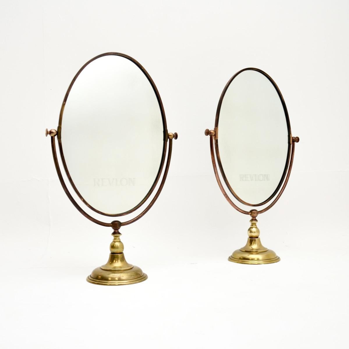Une belle paire de miroirs de vanité vintage en laiton massif par Peerage. Fabriqués en Angleterre, ils datent des années 1960.

La qualité est exceptionnelle, ils sont magnifiquement faits et ont un beau design. Les miroirs ovales peuvent être
