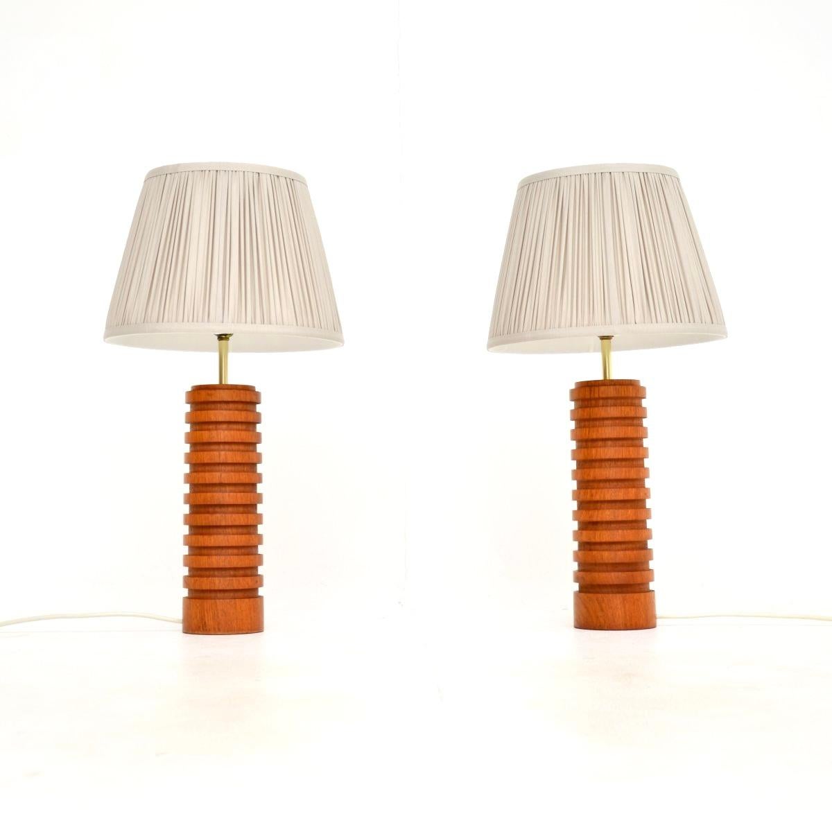 Ein stilvolles und sehr gut gemachtes Paar von Vintage-Tischlampen aus massivem Teakholz und Messing. Sie wurden in England hergestellt und stammen aus den 1960er Jahren.

Sie haben ein wunderschönes, gegliedertes Design und eine tolle Größe. Das