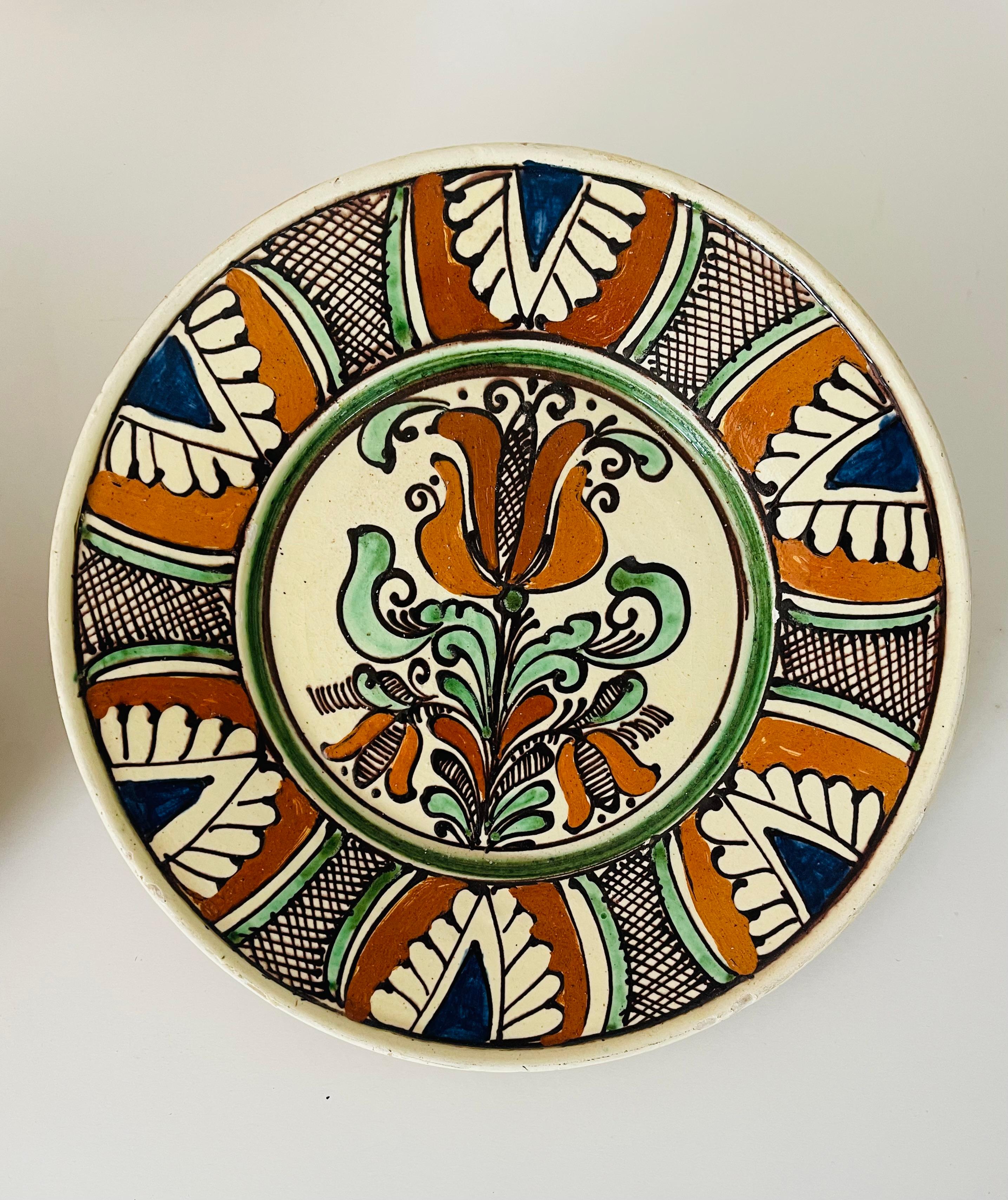 Pair of Spanish folk art glazed ceramic polychrome hand painted plates, 11” and 10” each. Signed verso.