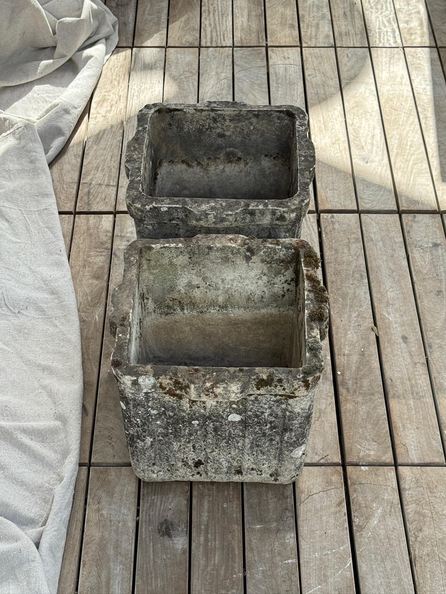 Offered here is a handsome pair of vintage square cast stone garden planters, beautifully aged with time-earned patina. Each planter features thick, substantial walls with a refined fluted vertical relief and gently scalloped rims that give them an