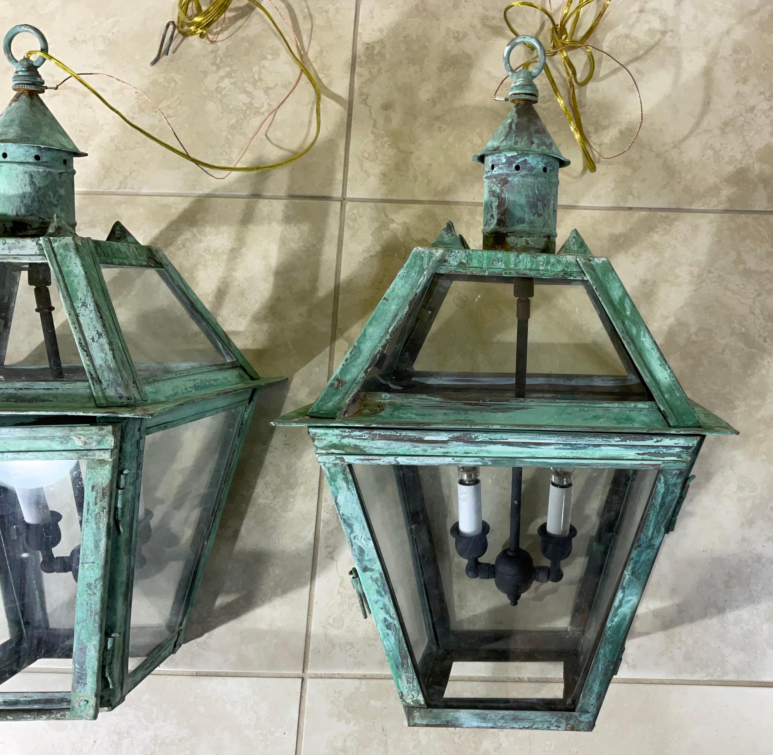 

par de hermosos faroles vintage con una bonita pátina oxidada. de cobre o latón. Los faroles tienen un diseño tradicional y clásico, con forma hexagonal y parte superior abovedada. Tienen cristales que dejan pasar la luz, y la construcción en