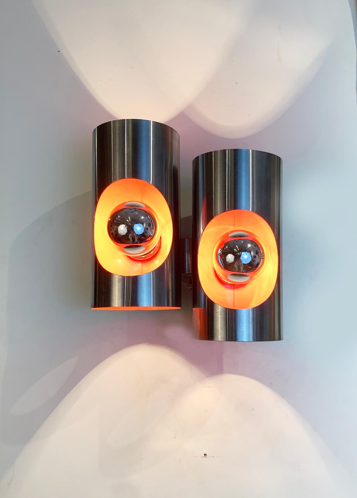 Curved stainless steel pair of sconces, with orange color from the inside, circa 1970s.