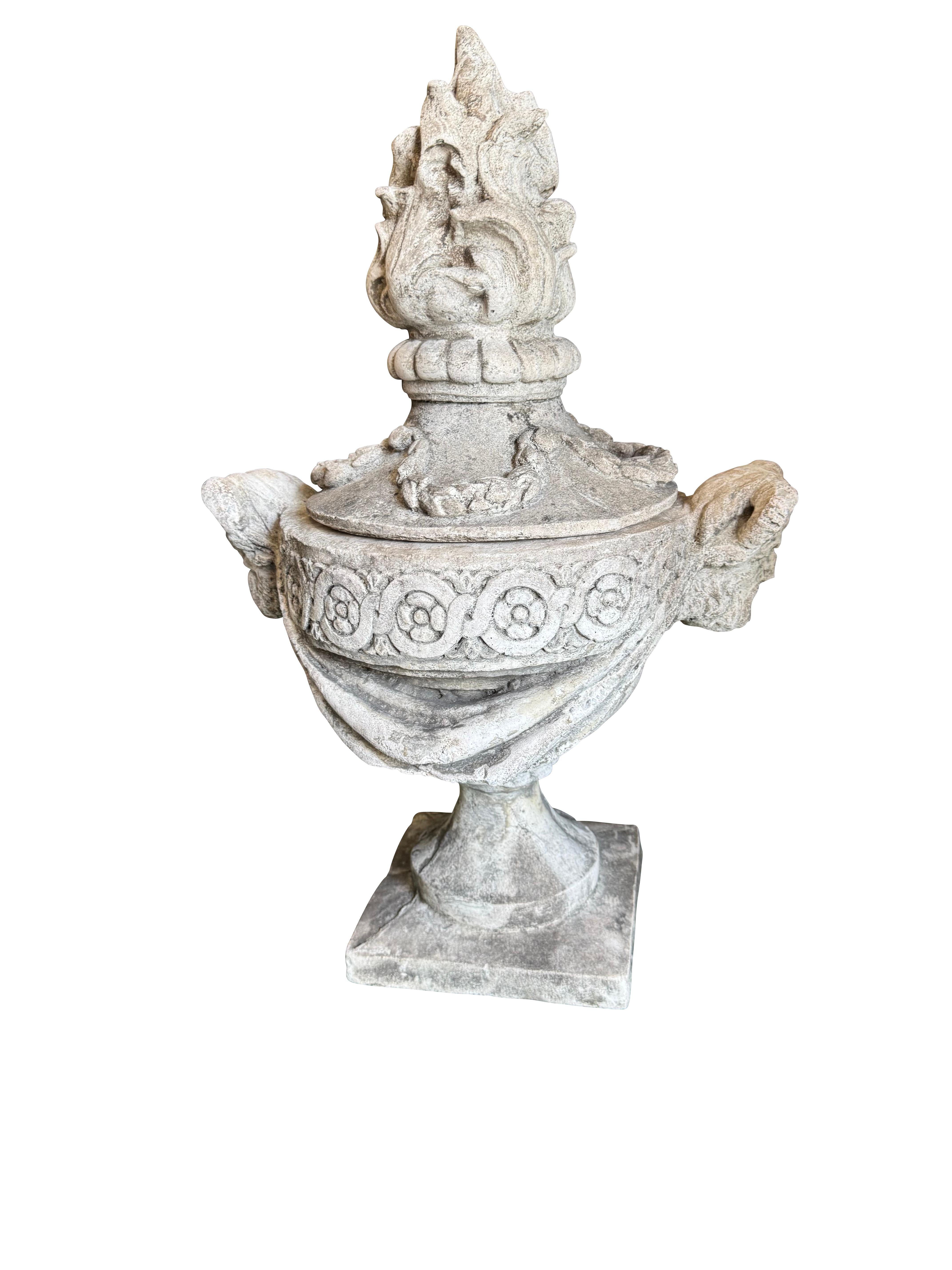 Ces urnes de jardin sont très décoratives et de style classique. Ils sont fabriqués en pierre (ou en pierre moulée) et présentent des détails complexes :
    •    Forme : Les urnes sont recouvertes d'un couvercle surmonté d'un grand fleuron en forme