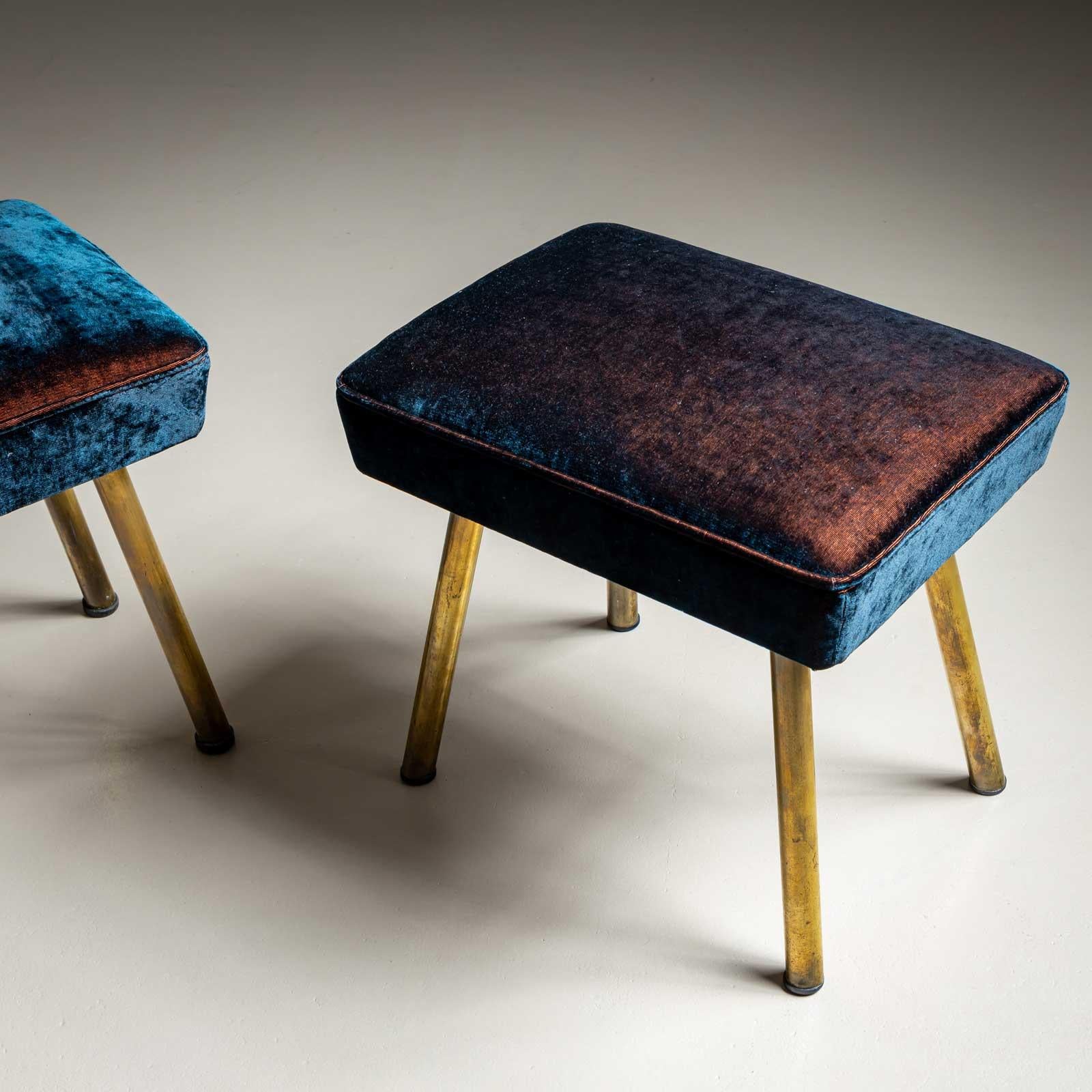 Une paire de tabourets vintage avec des sièges rectangulaires et des bases à quatre pieds en laiton. Les tabourets ont été retapissés avec un tissu de haute qualité dans une couleur allant du cuivre au bleu foncé.