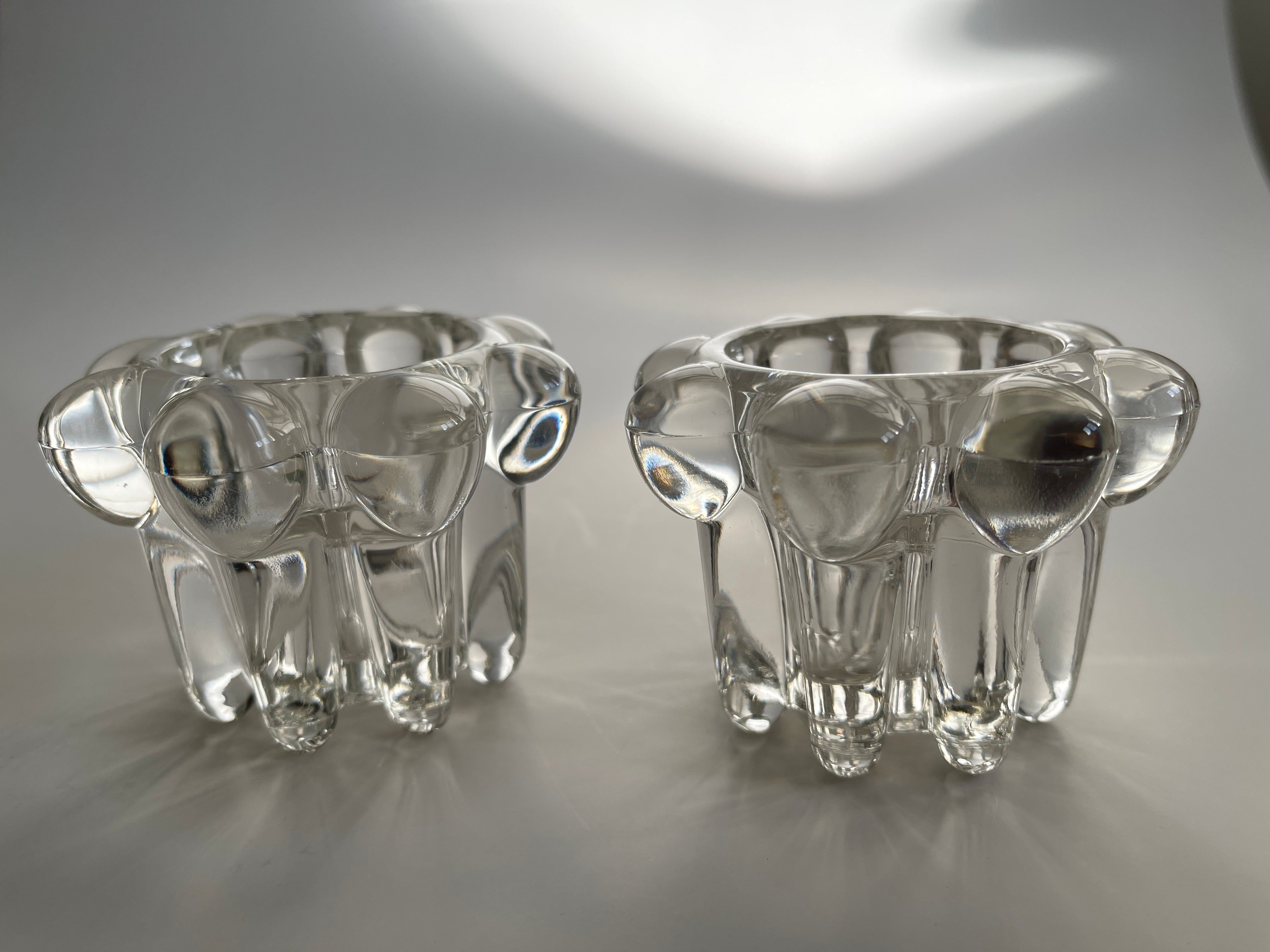 Pair of vintage Swedish glass curved flower candle holders. Beautiful light catching sculptures by day, and gorgeous illuminating the room by night.
May be used with votive candles or candlesticks, they are designed to fit both.