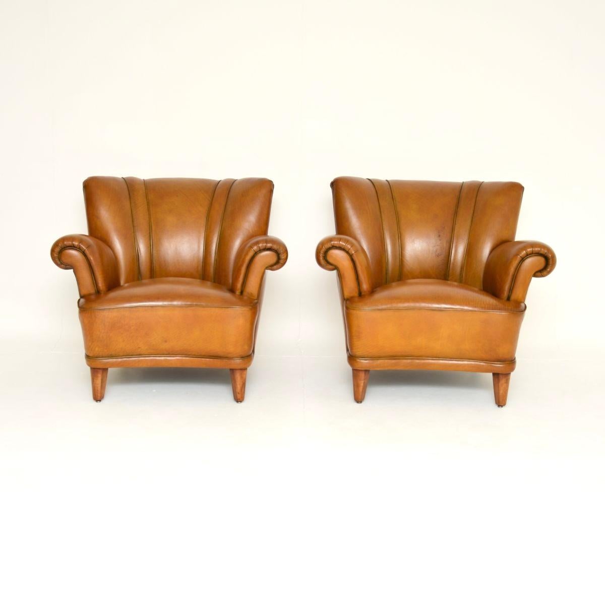 Superbe paire de fauteuils club vintage en cuir suédois. Récemment importées de Suède, elles datent des années 1940 environ.

La qualité est exceptionnelle, les cadres galbés sont généreux, bien cintrés et extrêmement confortables. Ils reposent sur