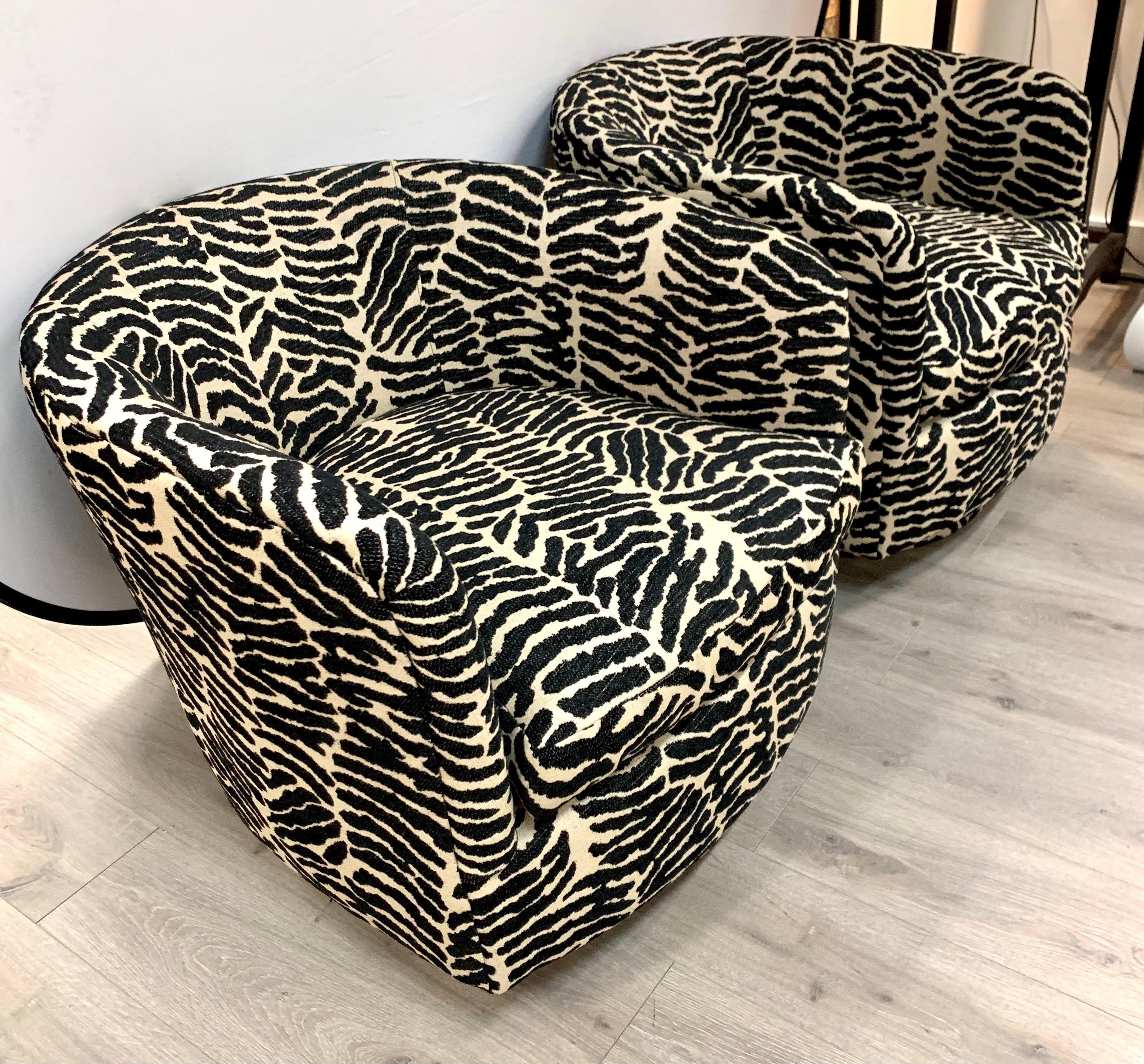 Midcentury swivel barrel back chairs have been newly upholstered in a black and white zebra print fabric. Loose seat cushion.