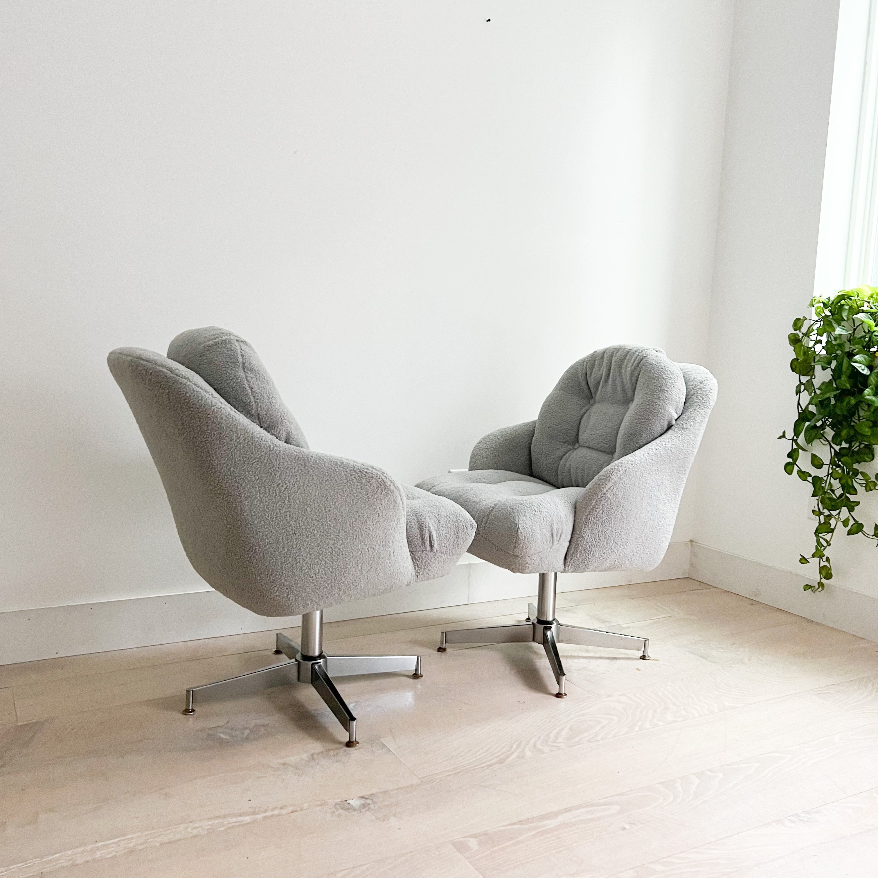 Introducing a captivating pair of vintage swivel lounge chairs, meticulously refurbished to exemplify both comfort and style. These chairs feature brand-new, luxuriously soft light grey shearling upholstery that effortlessly elevates their