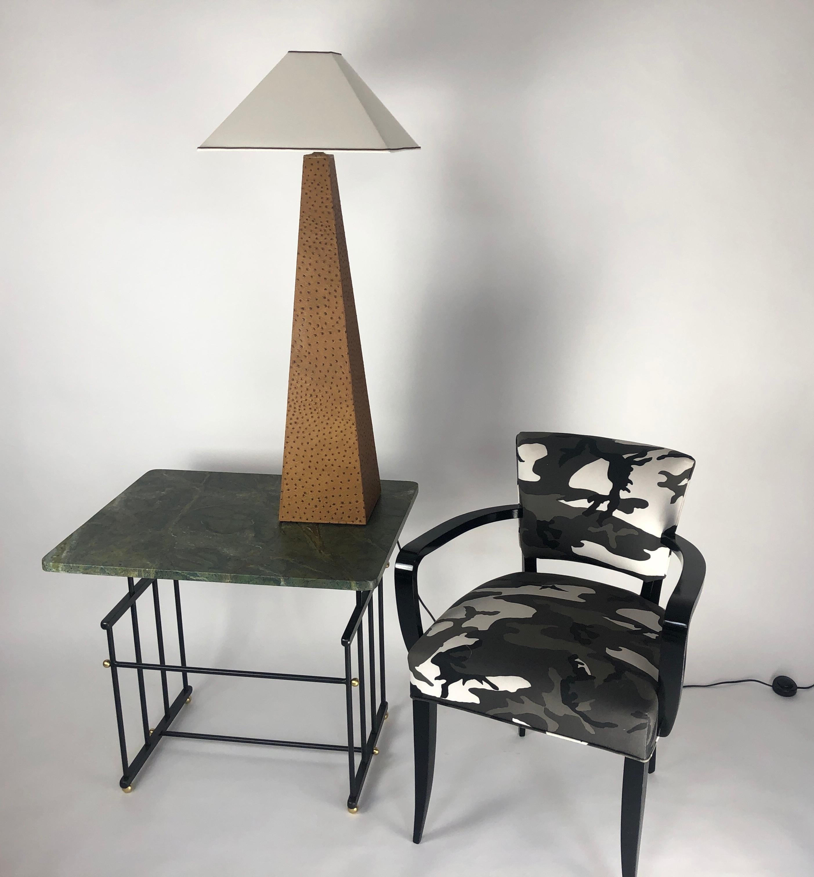 Two obelisk shaped lamps. They are covered in an embossed camel colored ostrich leather. The lamps have a new linen covered shade. The large scale lamps are very impressive in size. The light has one medium based bulb socket.  Lamps are in our NYC