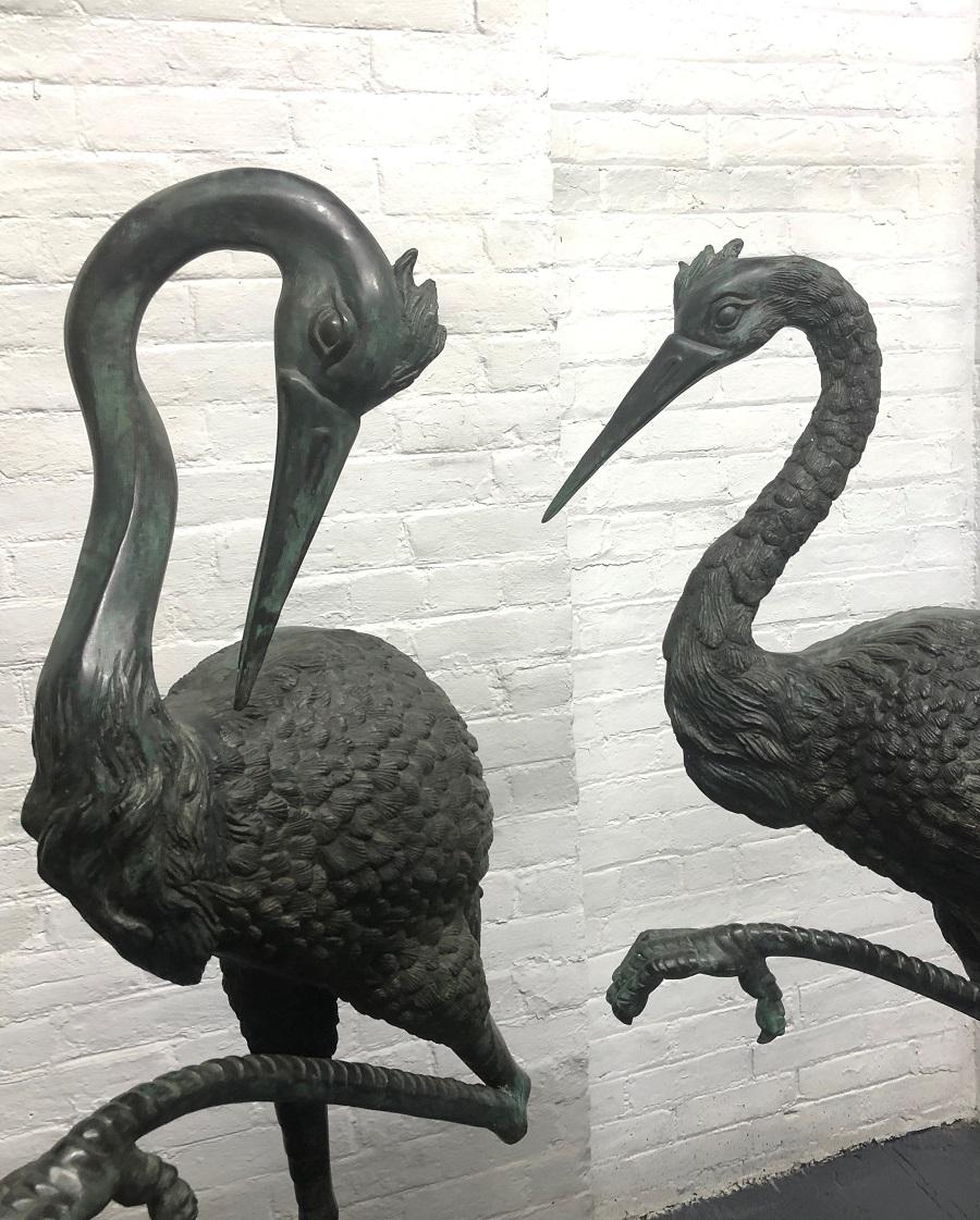 Pair of vintage tall bronze sculptural cranes. These standing cranes have a nice patina and can be used indoor or outdoor. One crane is slightly taller.
Measures (Taller) 56 H x 23 W x 12 D. Shorter: 55 H x 21.5 W x 12 D.
 