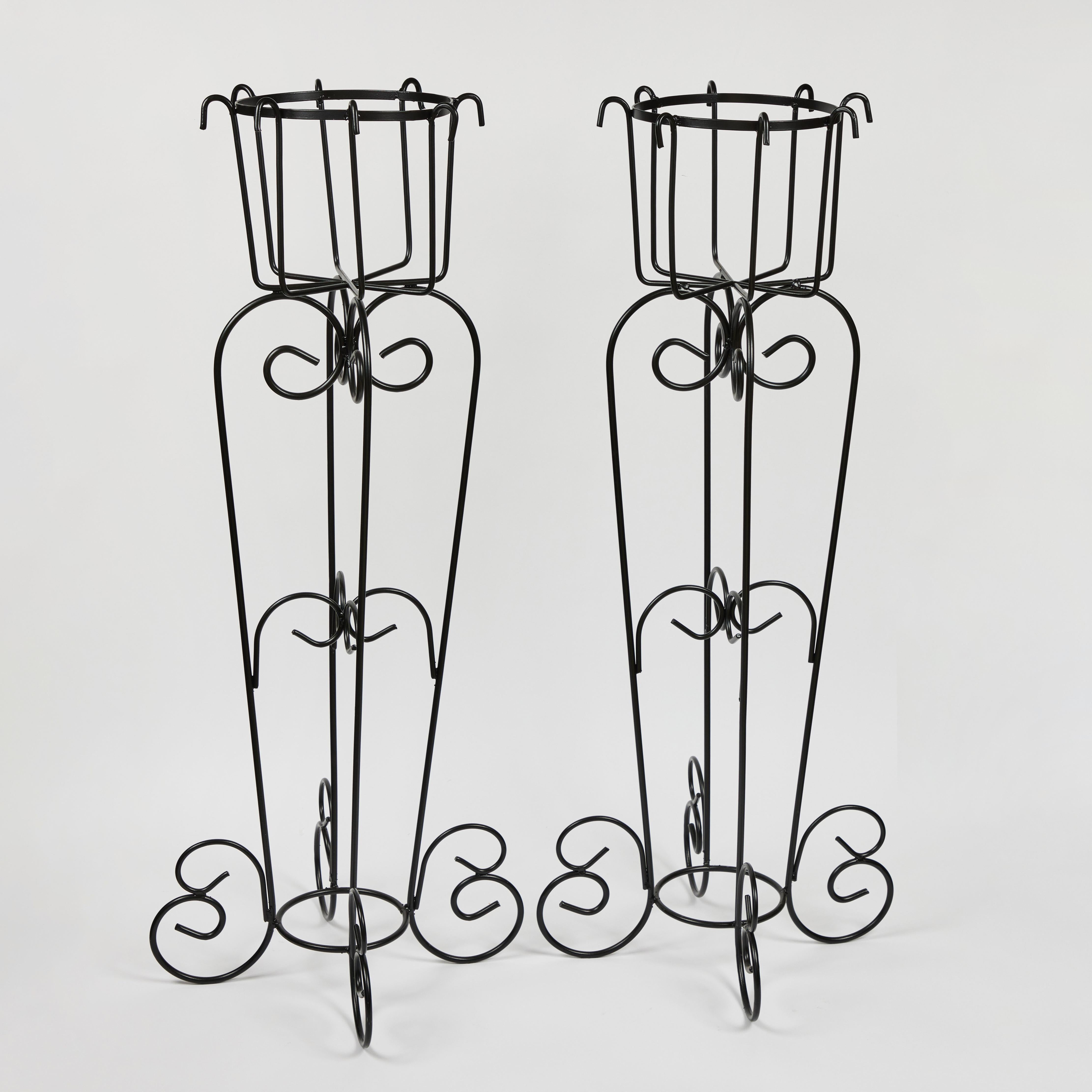 Splendid pair of tall vintage iron plant stands that have been newly powder coated in a rich black finish. They have a wonderfully robust presence even though they are airy and light with a repeating scroll design throughout.