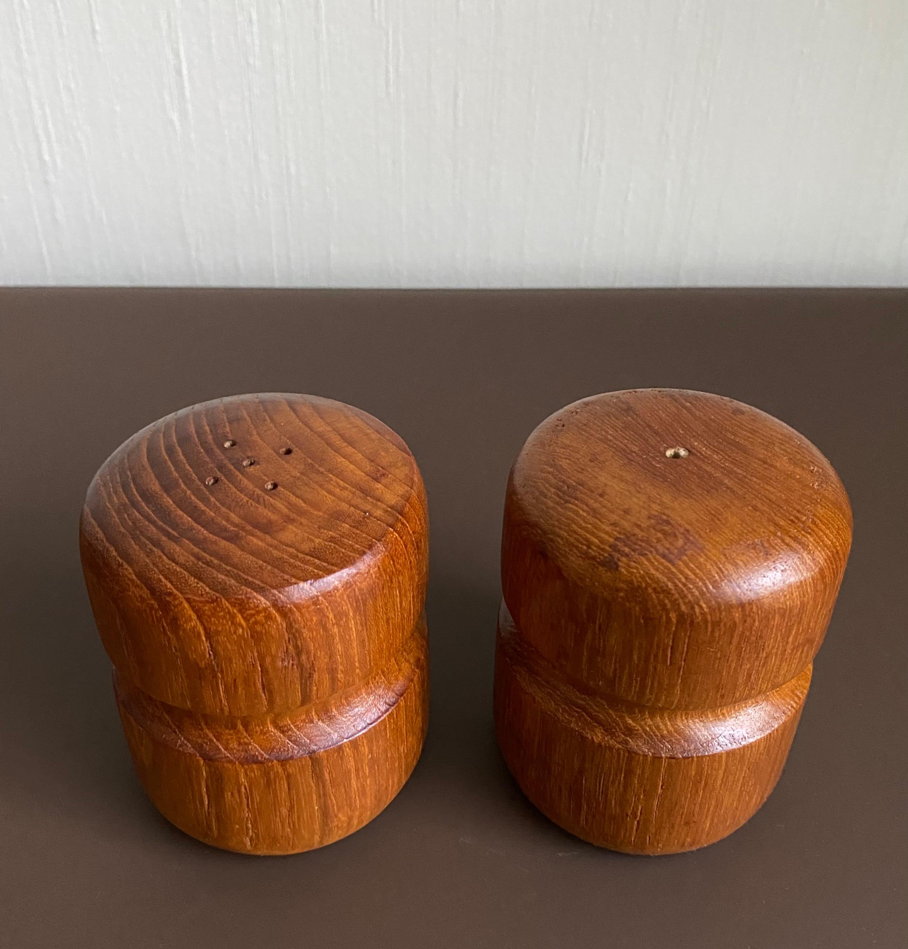 Vintage pair of Teak salt and pepper shakers with sculpted detail which fits the hand. Rubber stoppers to their bases.  In very nice condition with some normal signs of age and use.  Scandinavian Look.