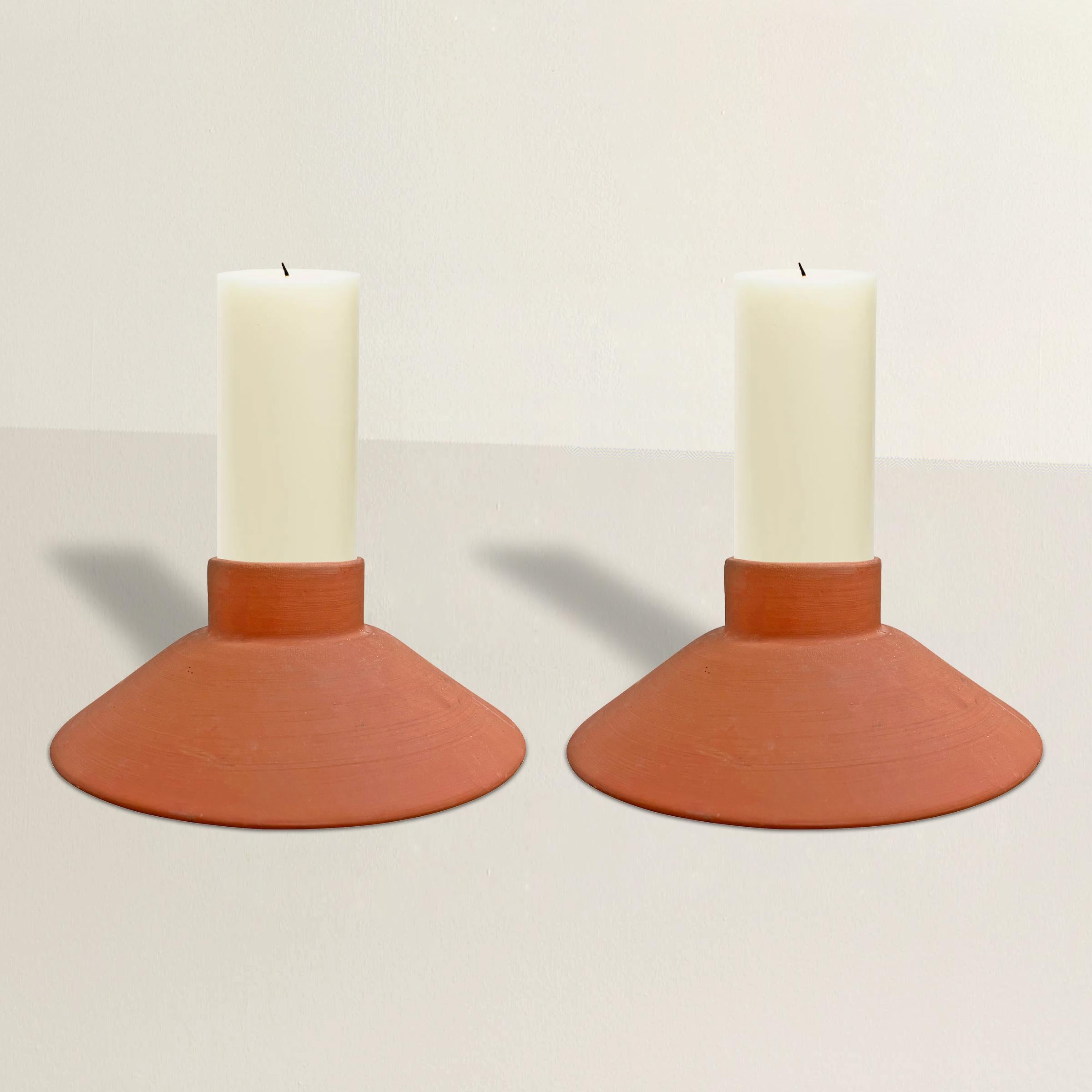 A chic pair of vintage terracotta pillar candle holders with a simple tapered shape that blends seamlessly into any style interior. Use on your dining table, coffee table, entry console, or cover with glass hurricanes and use them outside on your